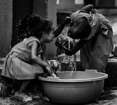 Children use water to wash their hands and face.