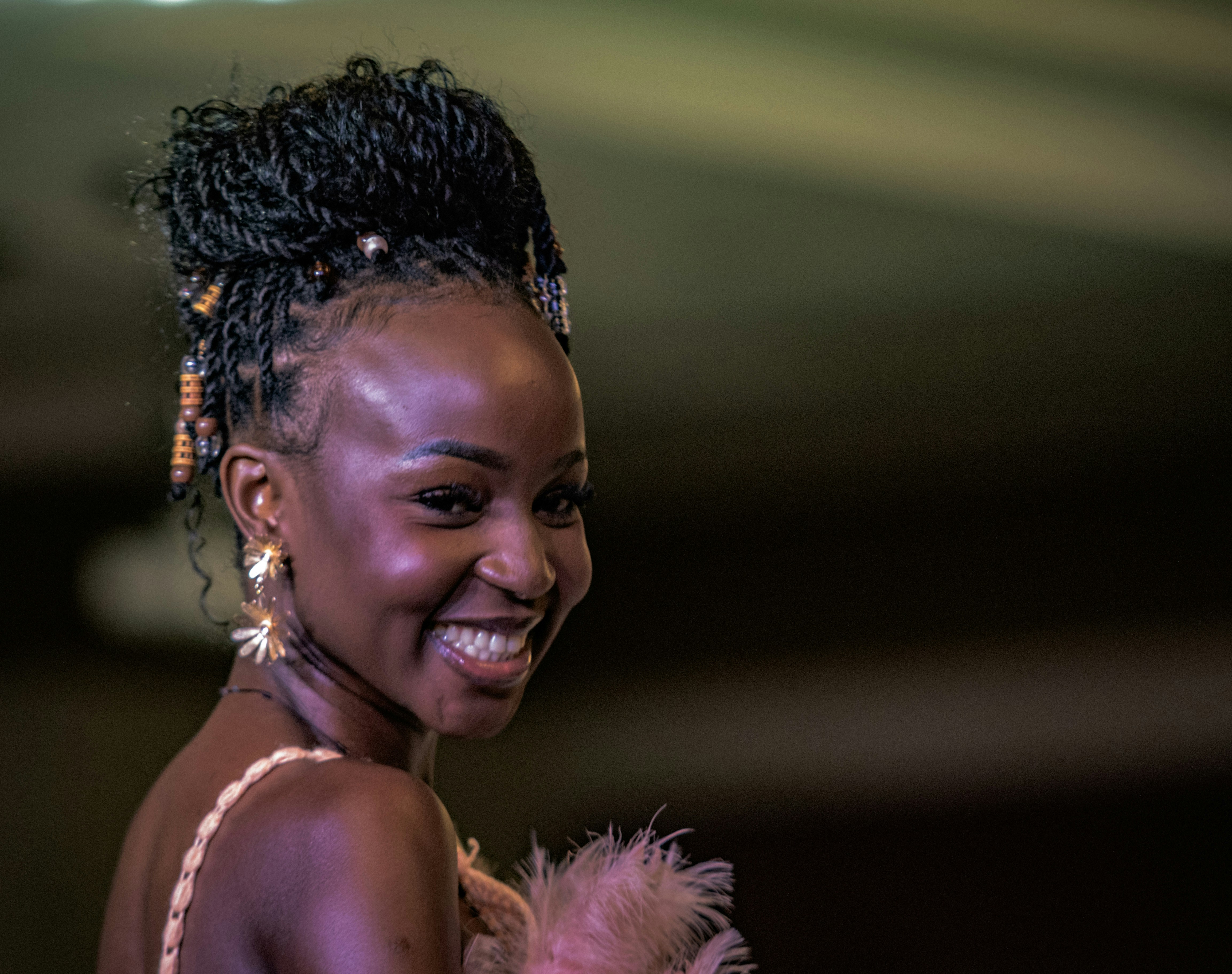A woman smiles with her hair in a bun.