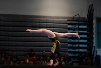 Gymnast performs a handstand on the balance beam.