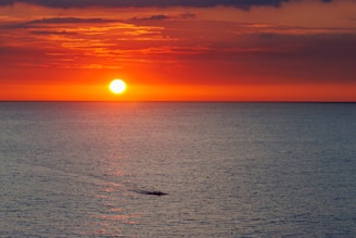 Sunset over the ocean creates a stunning scene.