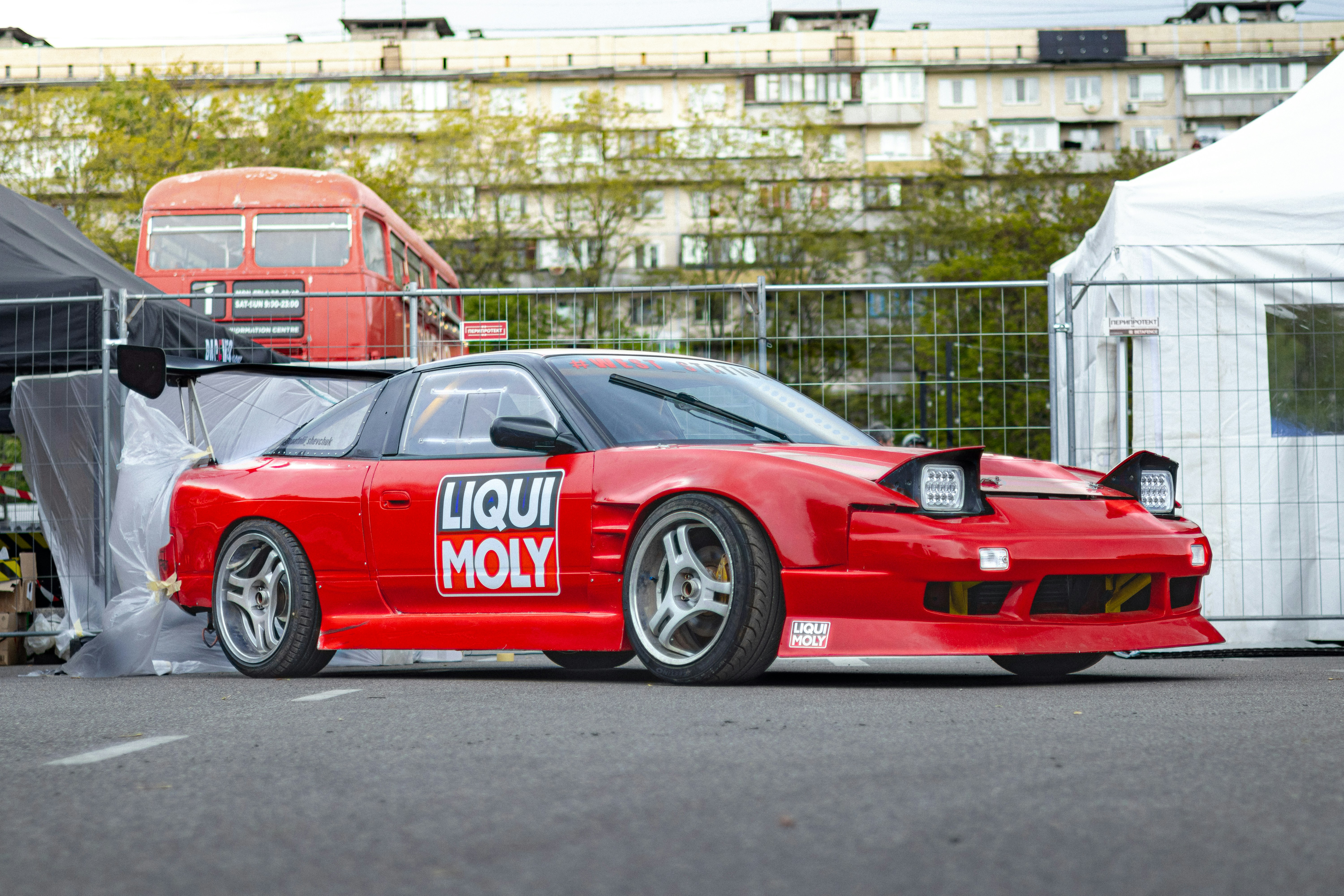 Mobil sport merah diparkir di luar.
