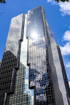 A tall, modern building reflects the sky.