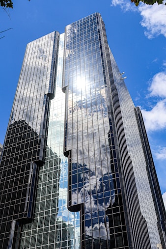 A tall, modern building reflects the sky.