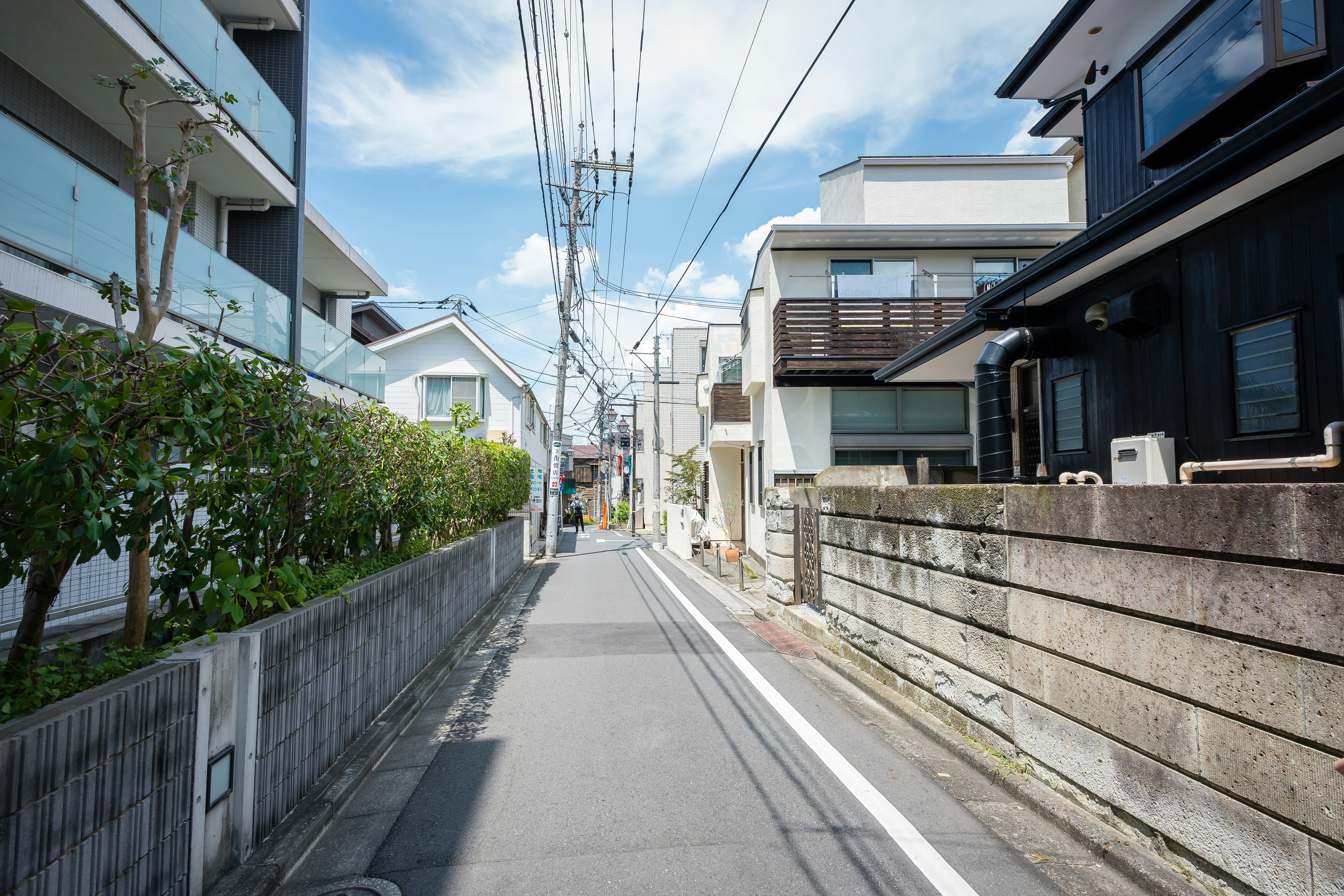 Eine schmale Straße zwischen Häusern an einem sonnigen Tag.