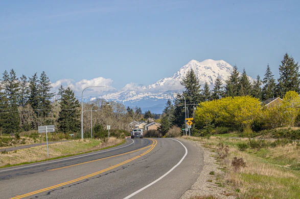 A winding road leads to snowy mountains.