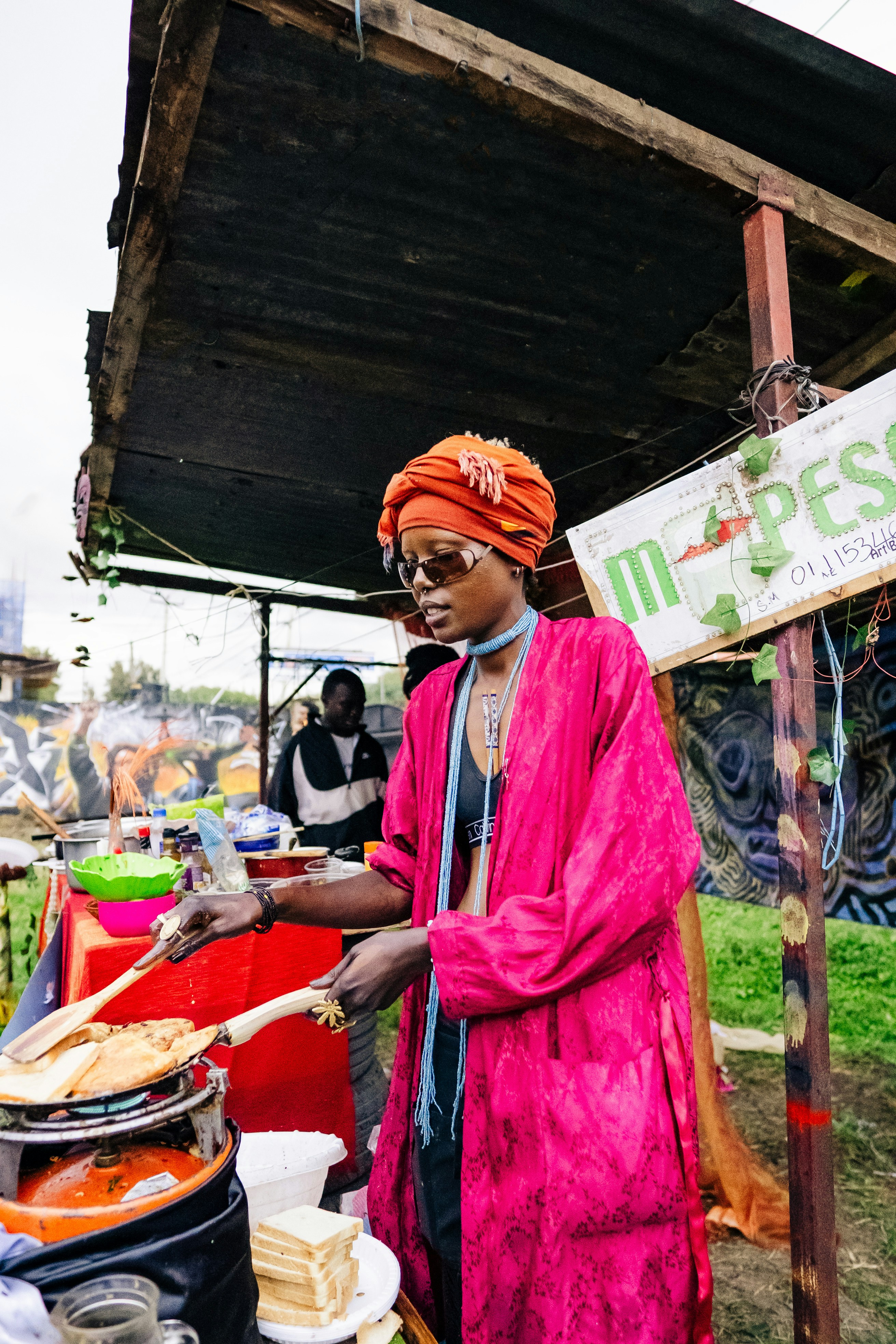 A vendor cooks food at a street stall.