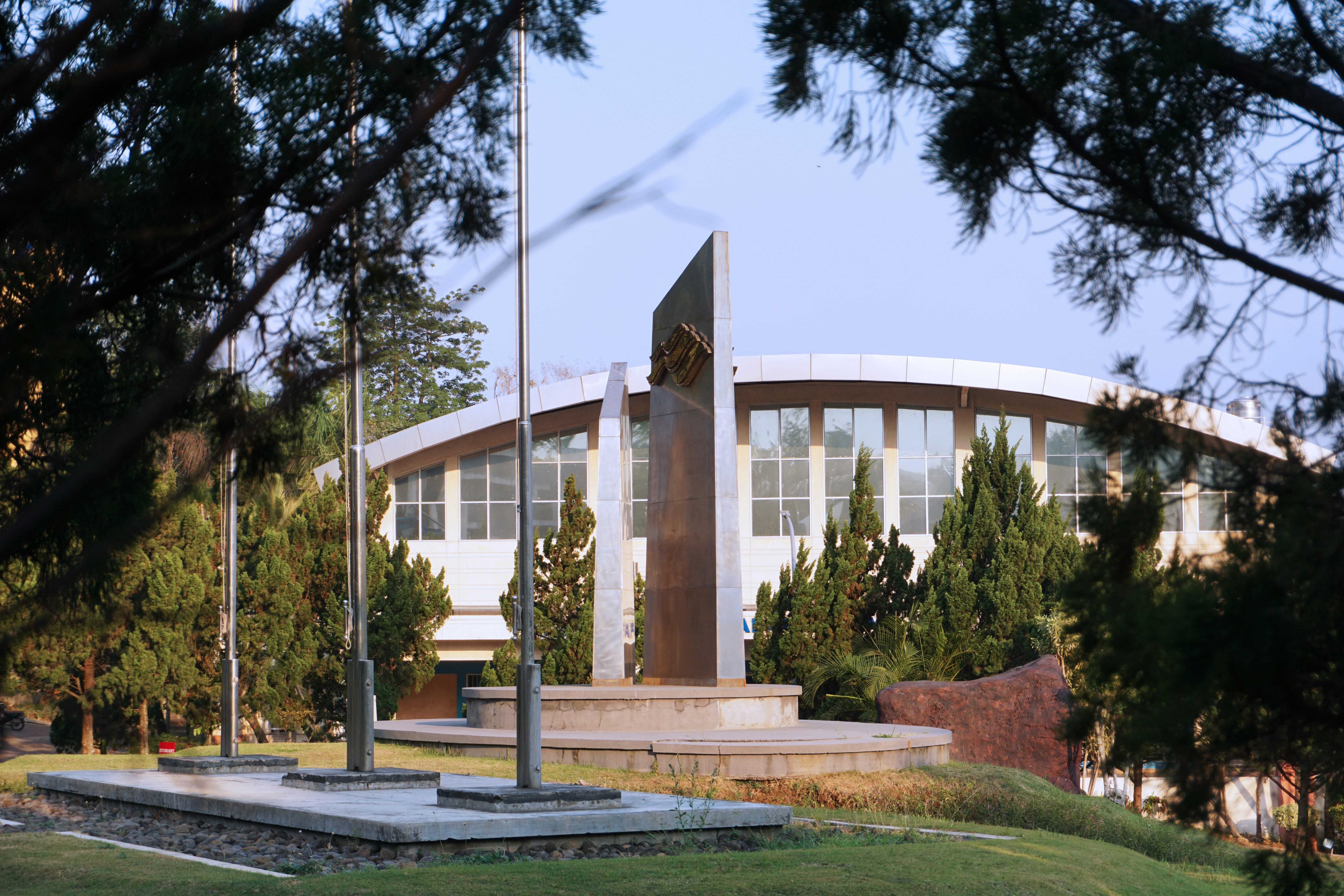 A building with a monument and trees.
