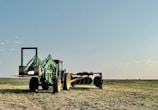 A tractor plows a field on a sunny day.