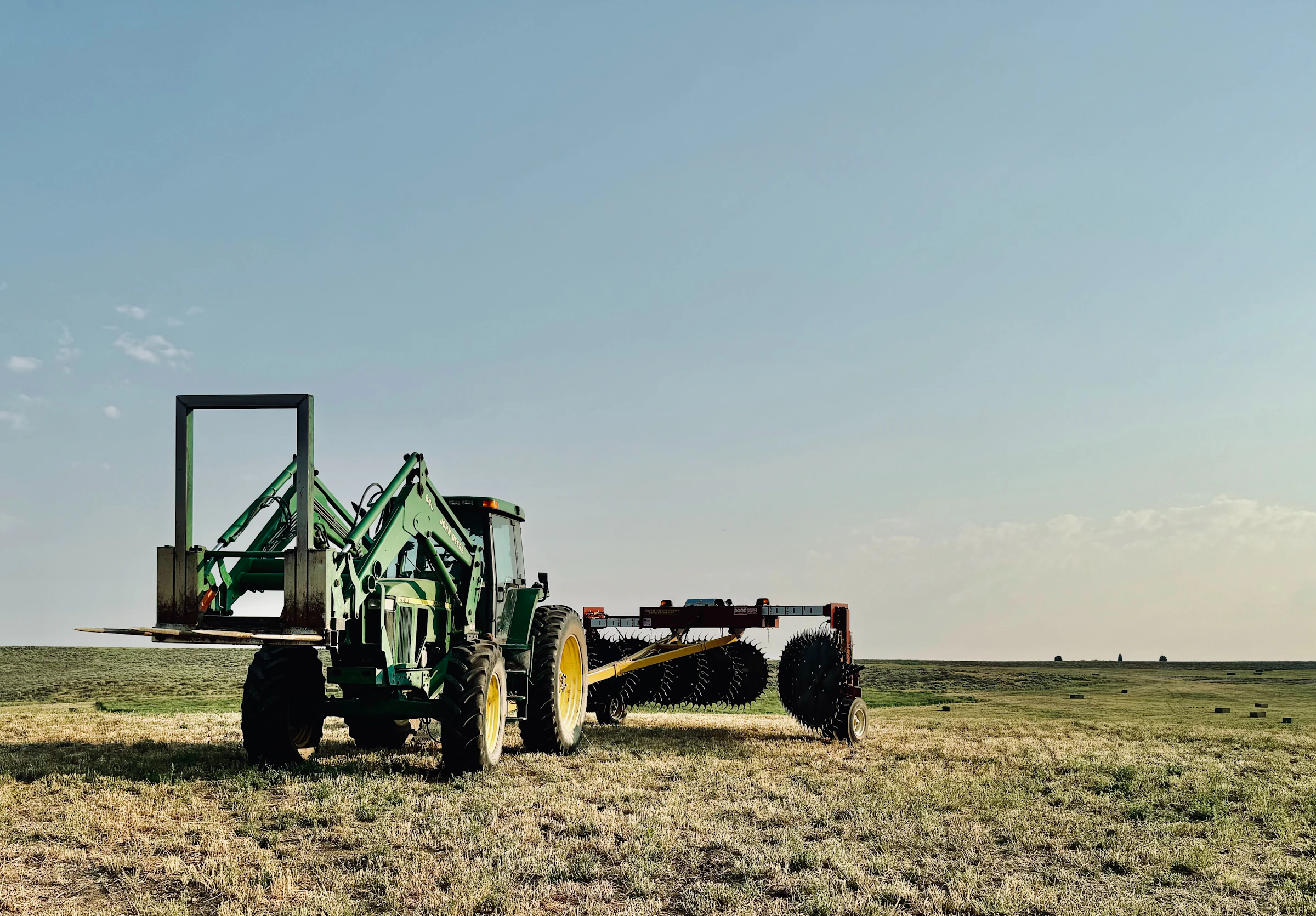 A tractor plows a field on a sunny day