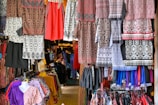 Clothes are displayed for sale in a colorful shop.