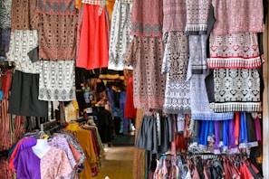 Clothes are displayed for sale in a colorful shop.