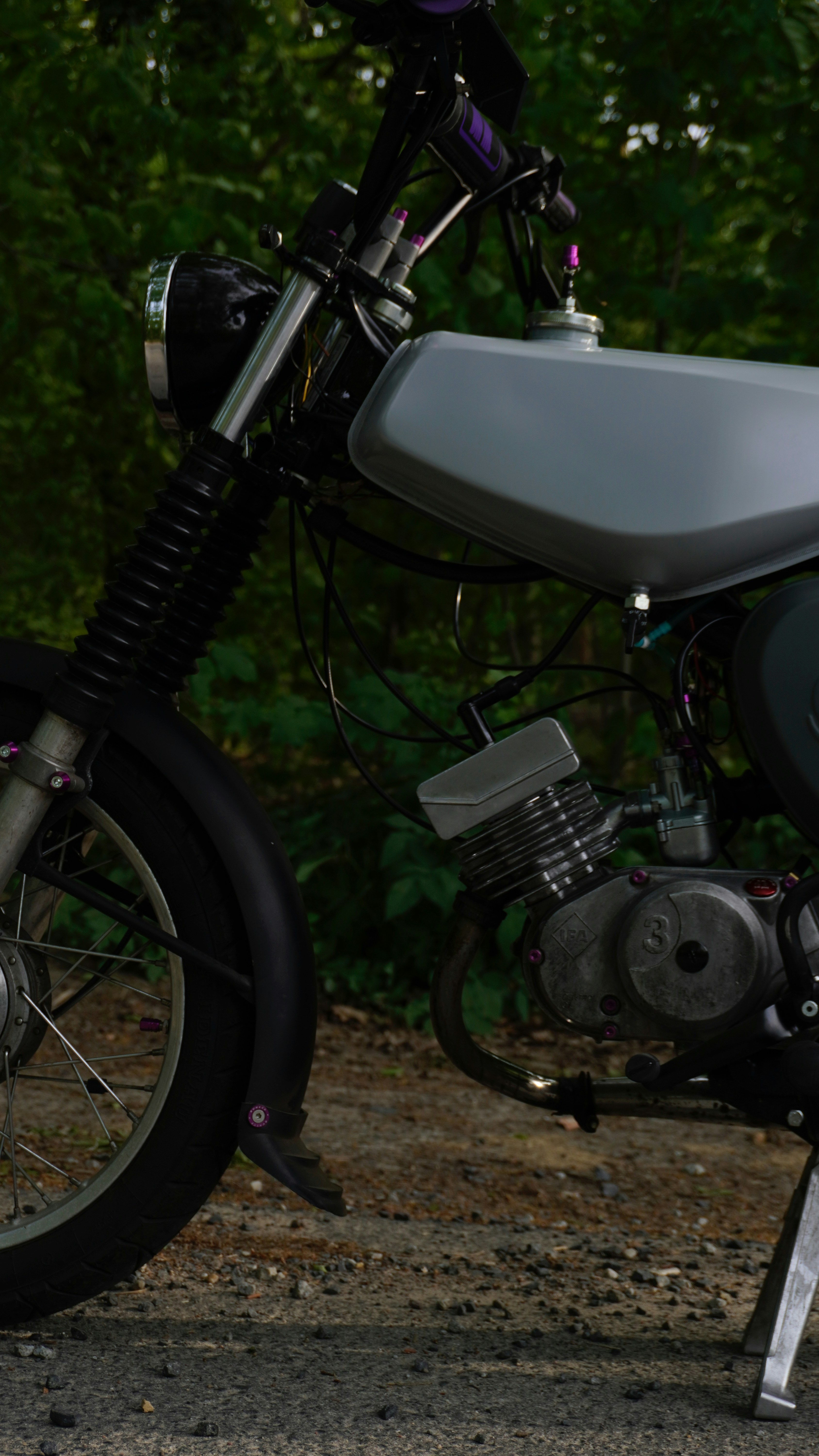A vintage motorcycle is shown with a scenic background.