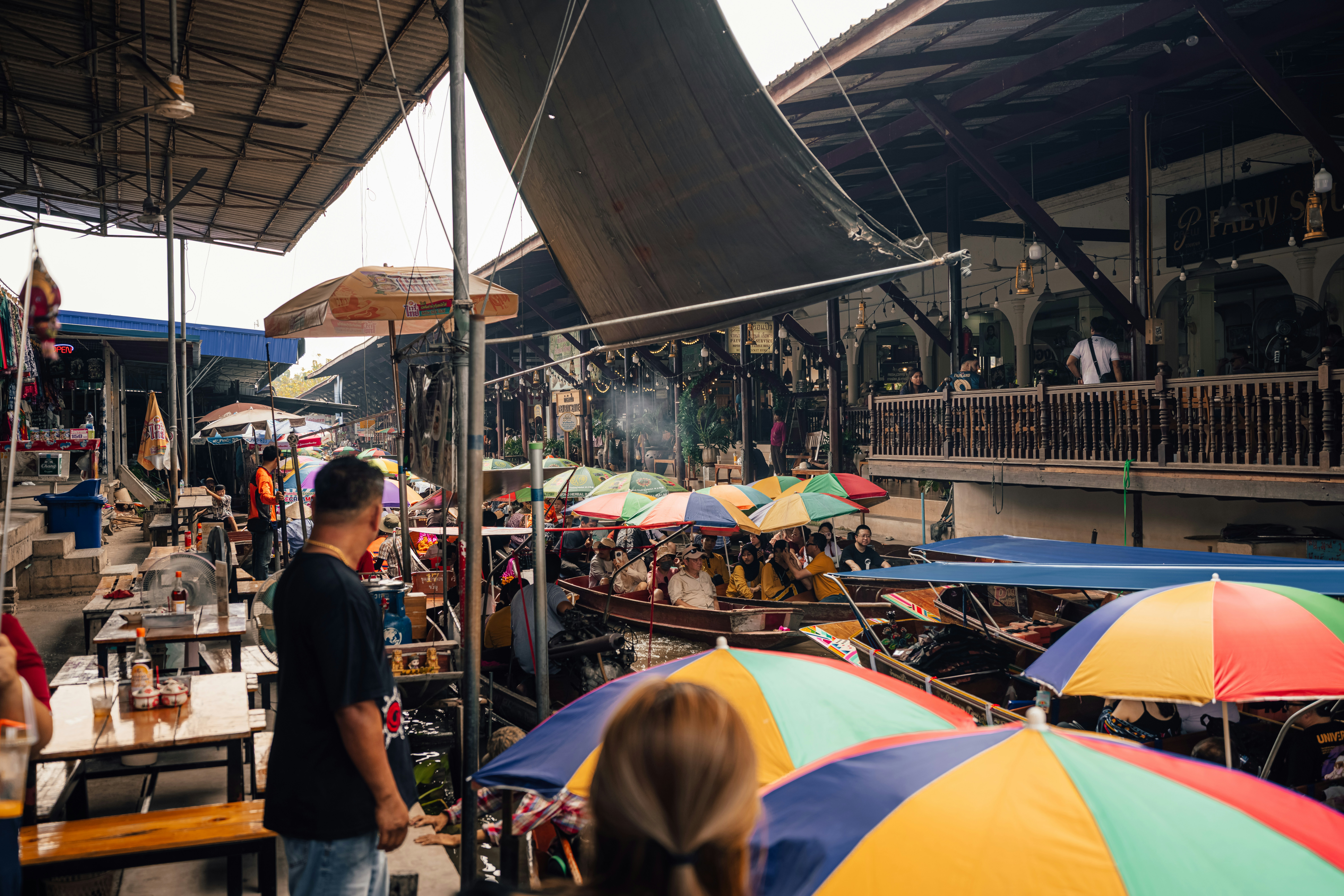 A busy floating market scene with colorful umbrellas.