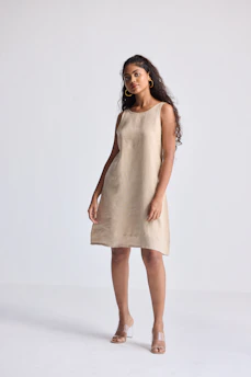 A woman poses in a simple linen dress