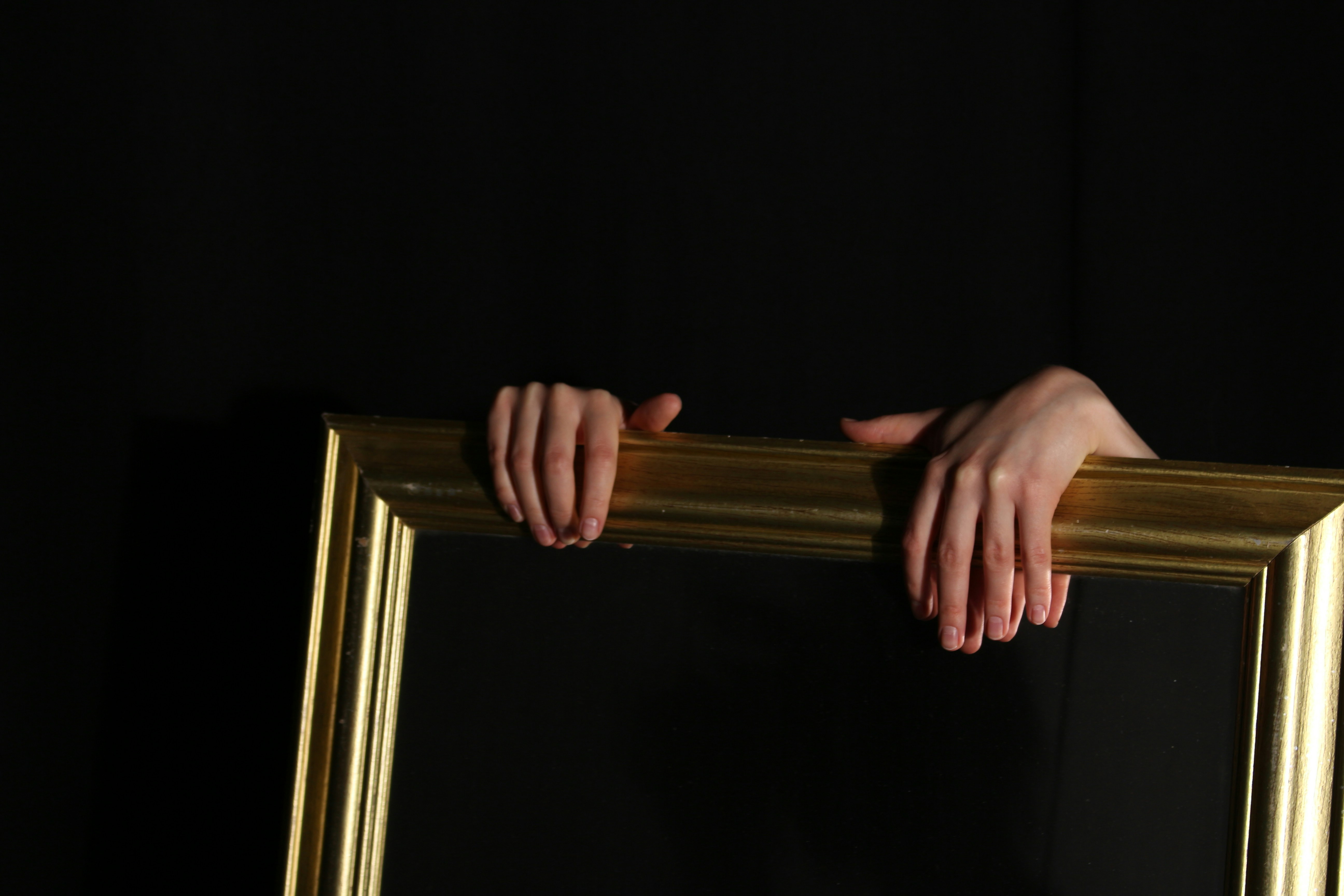 Hands appear above a gold picture frame.
