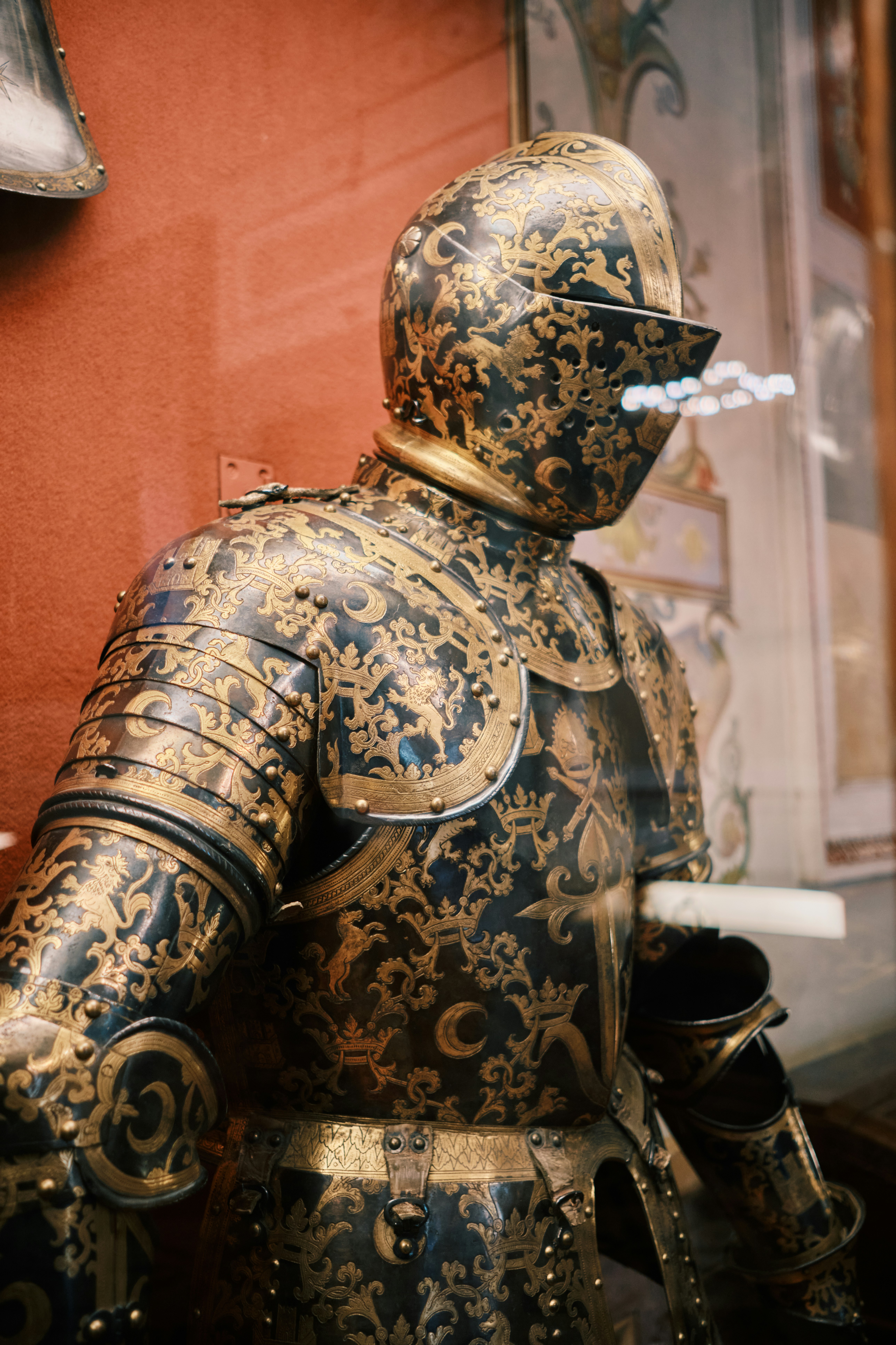 Ornate armor is displayed in a museum exhibit.