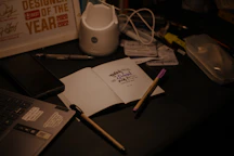 Desk with pens, notepad, and various objects.