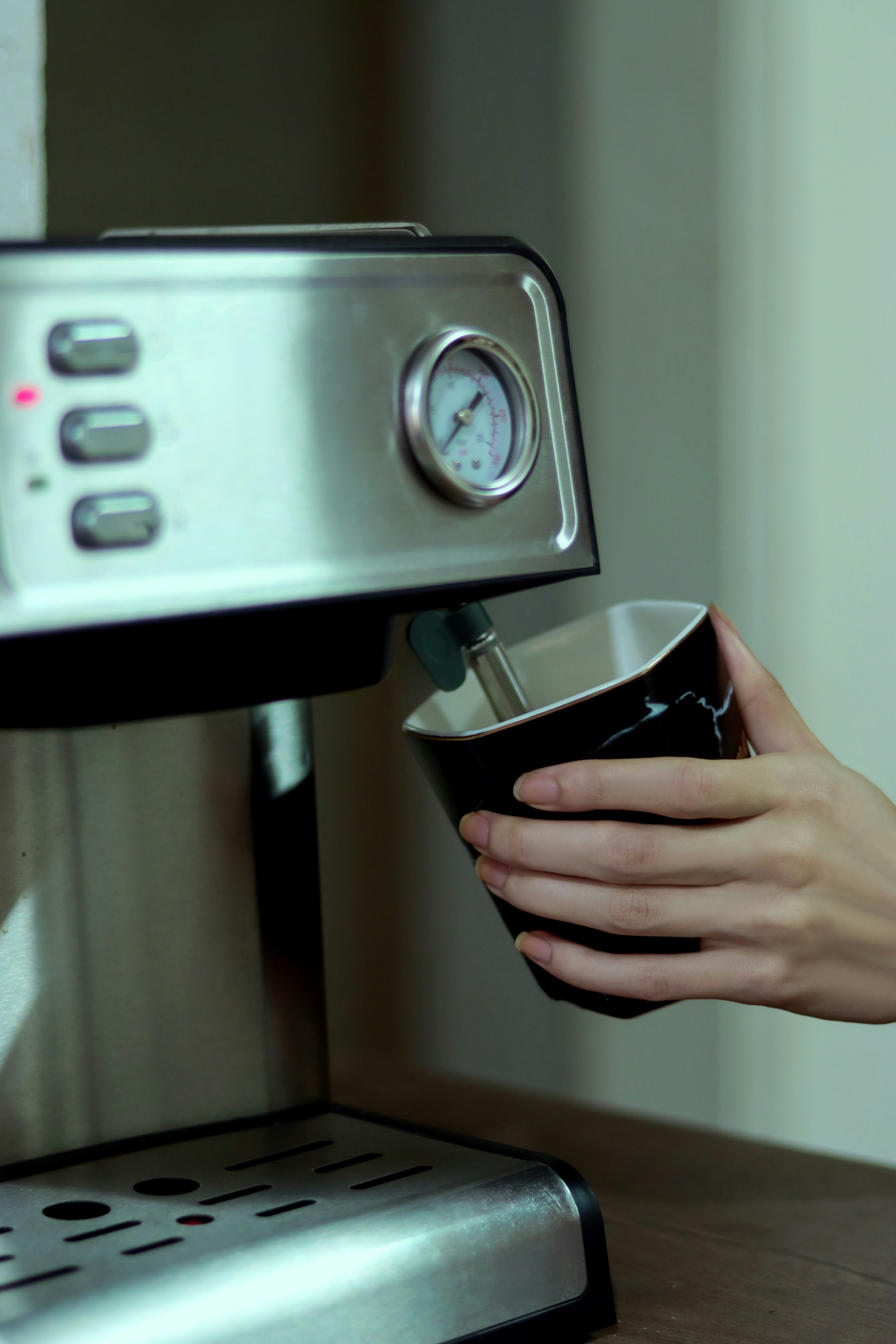 Person making coffee with an espresso machine.
