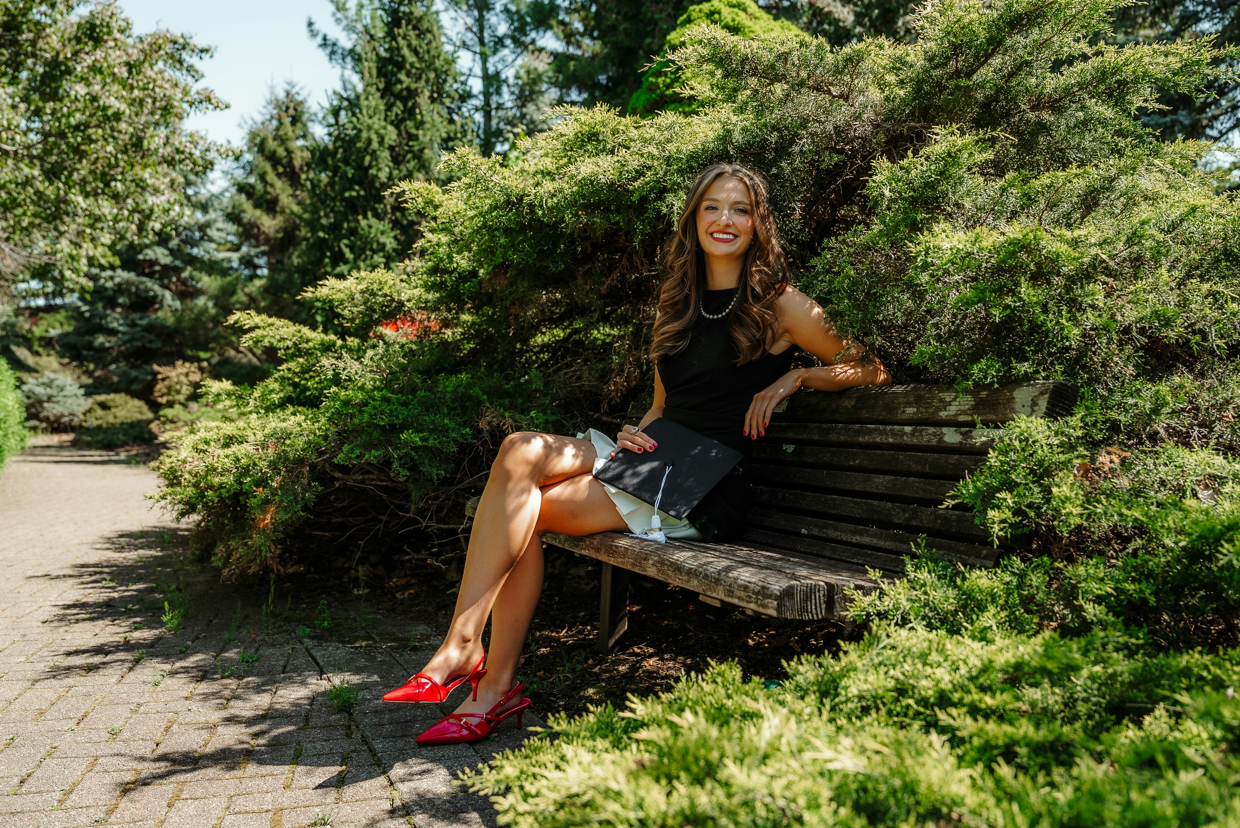 Frau posiert glücklich auf einer Bank in einem Park.