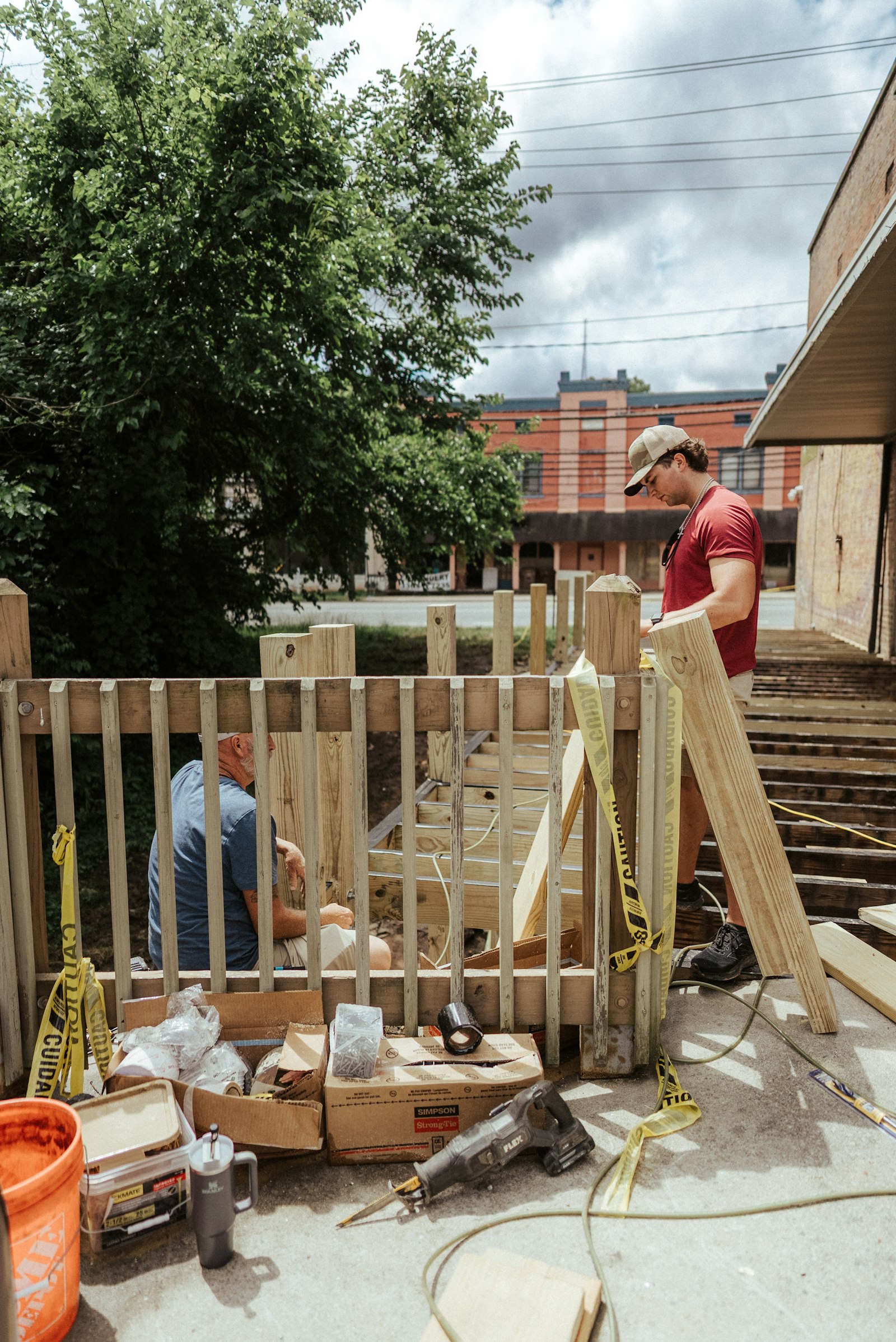 Two workers putting up a wood fence