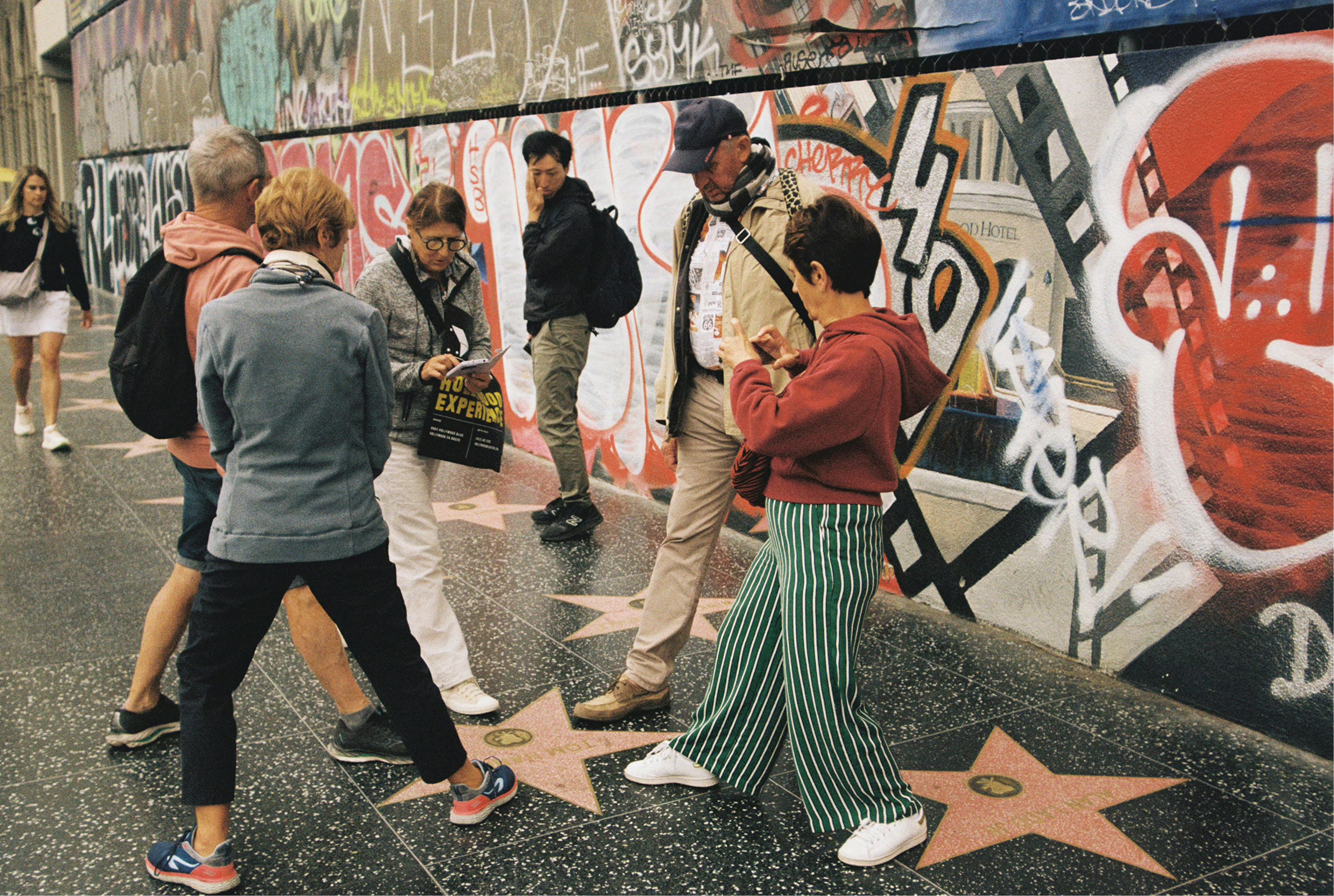 People are walking the hollywood walk of fame.
