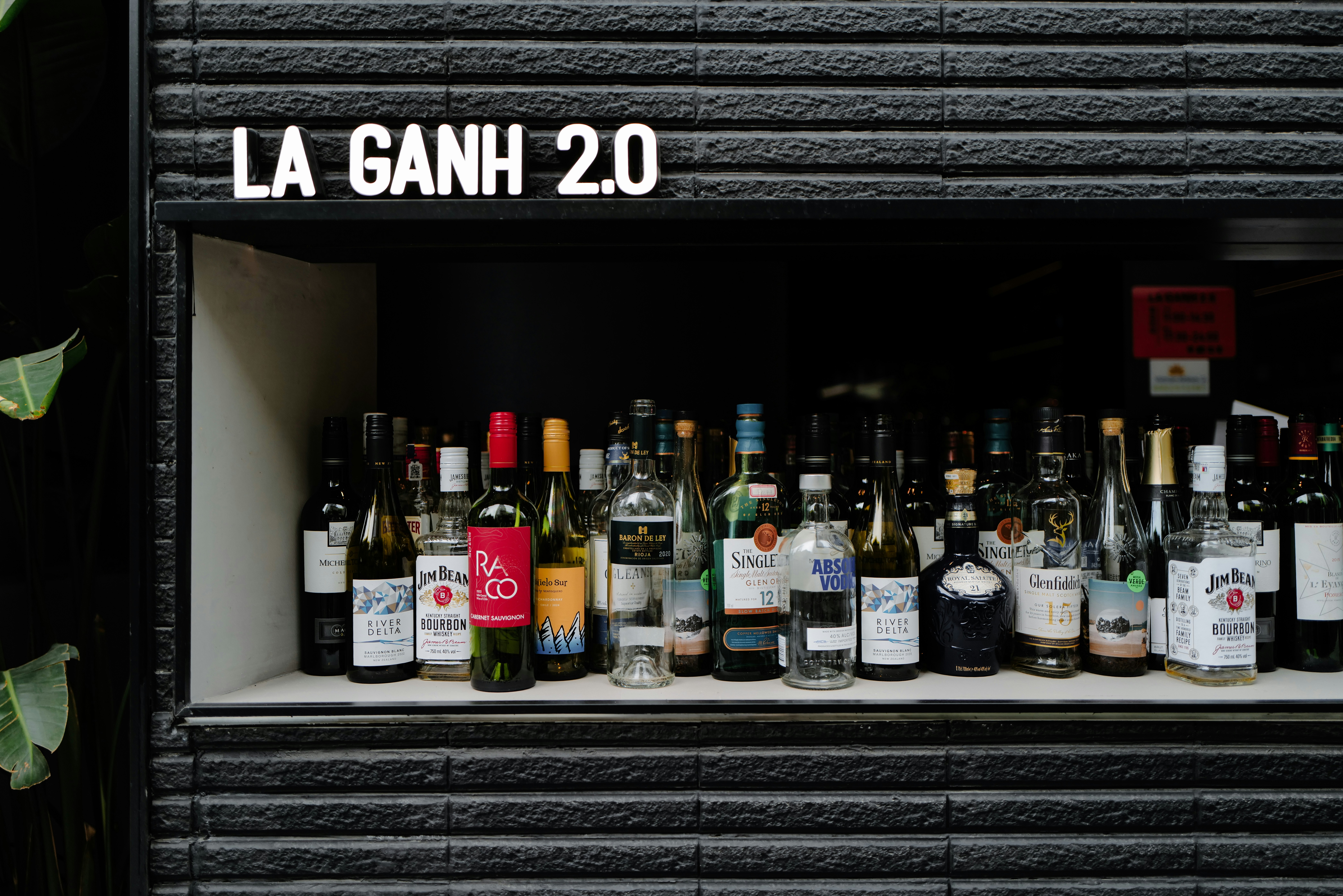 Bottles of alcohol are neatly arranged on a shelf.