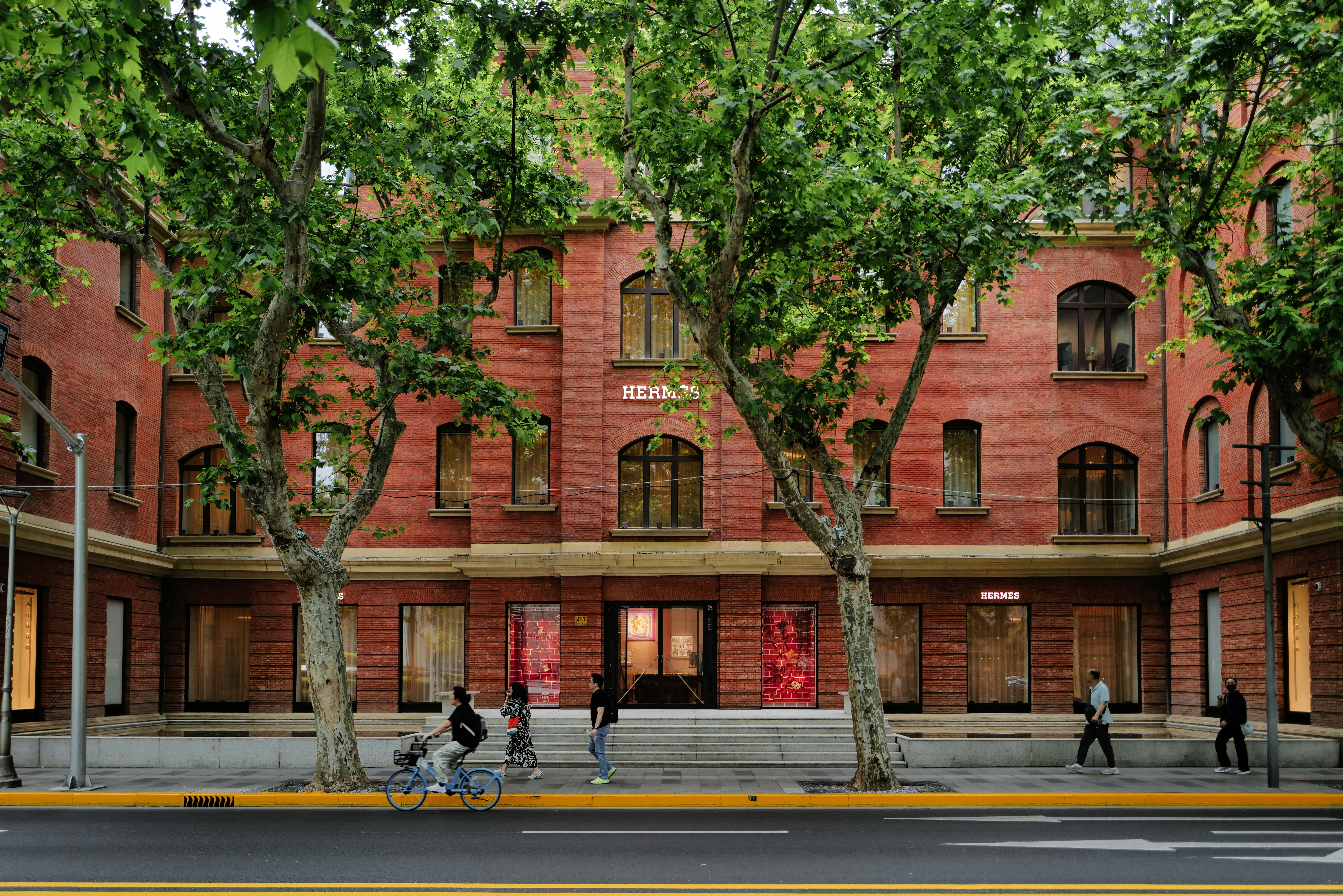A red brick building is situated across a street.