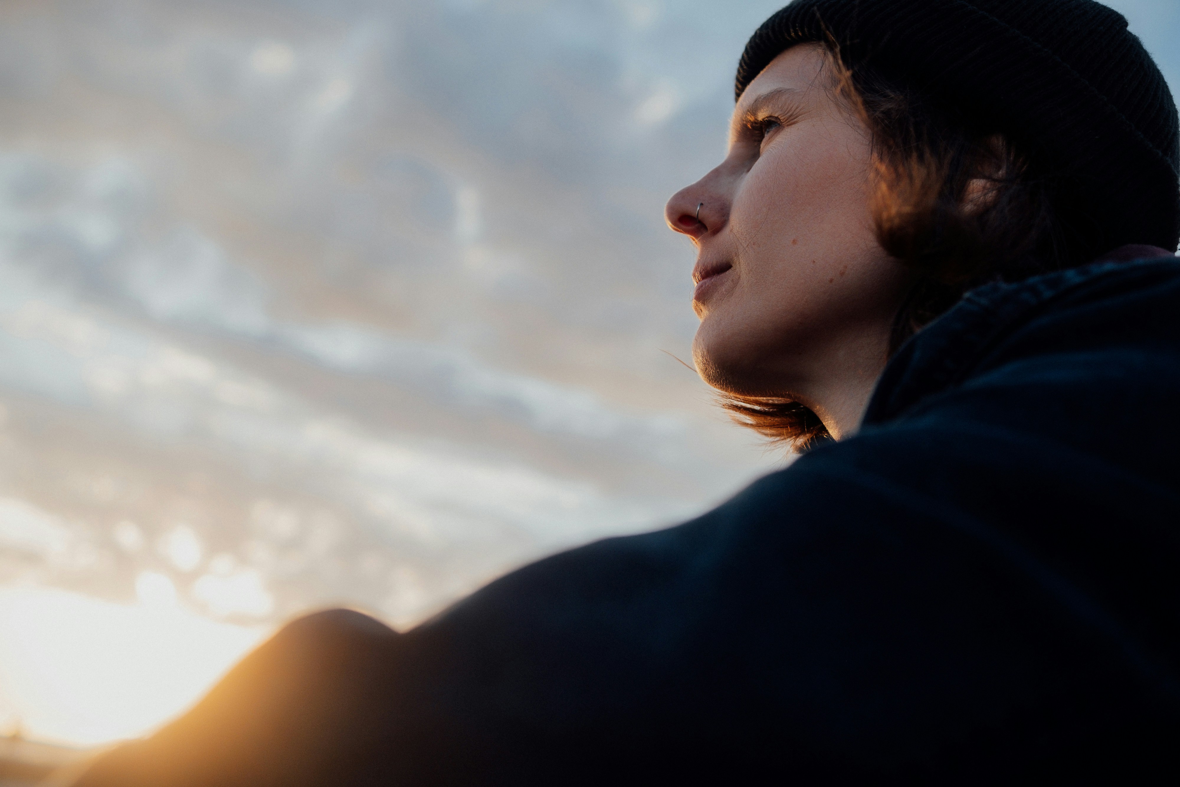 Woman looks out at the sunset sky.