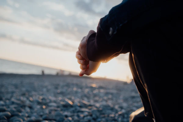 Personne contemplant la mer au coucher du soleil – introspection et transformation