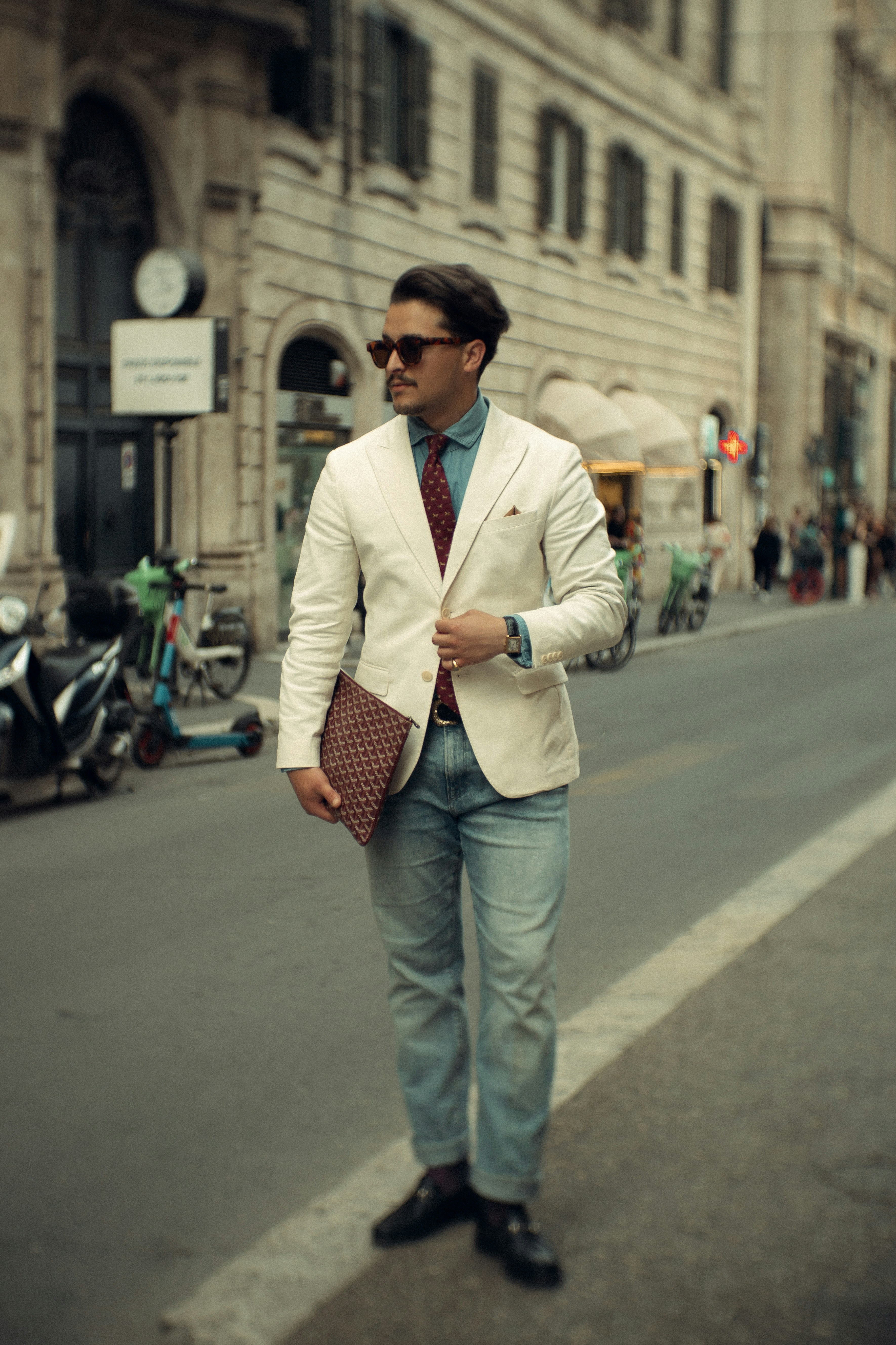 Stylish man poses on a street.