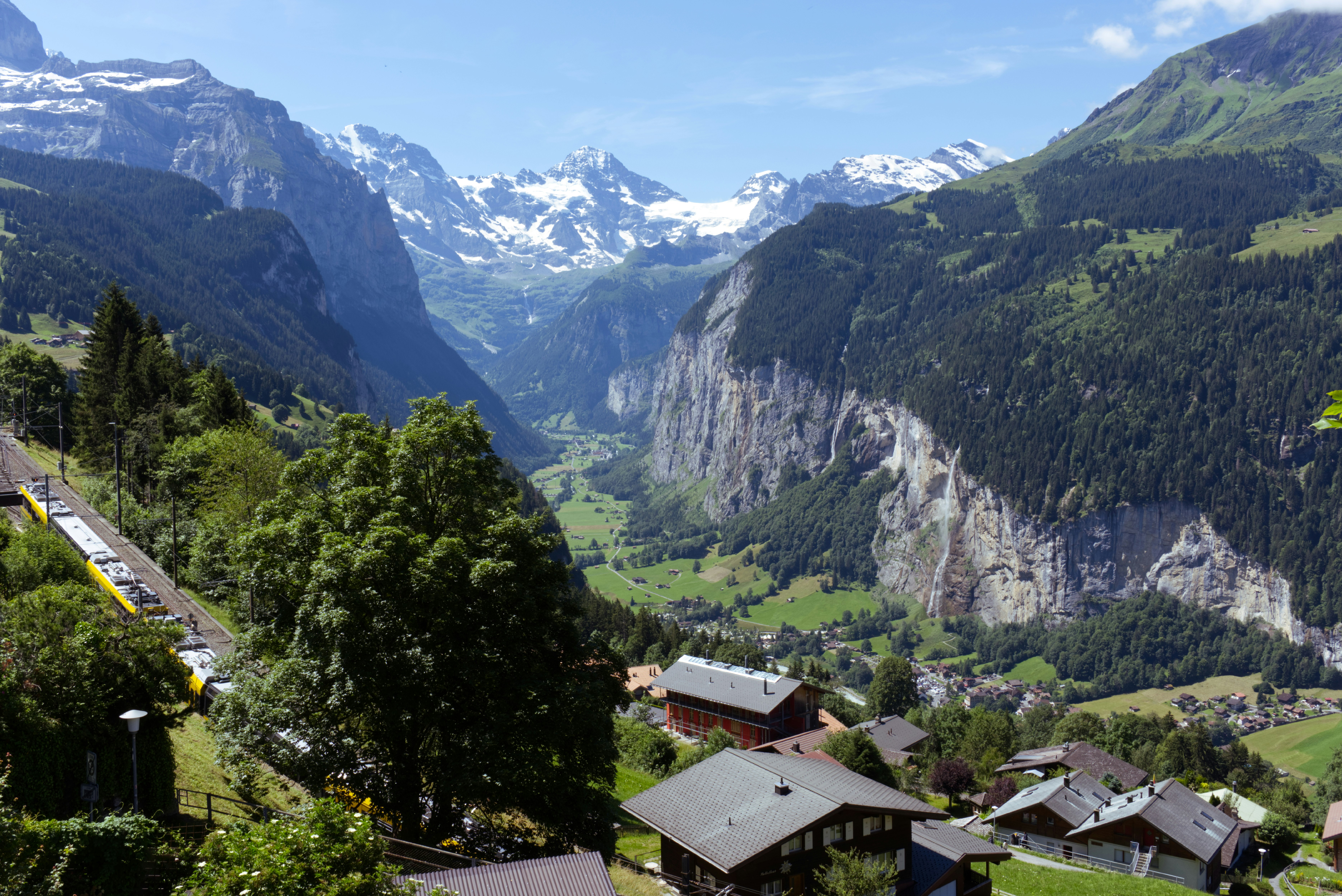Vista panorámica de un valle montañoso con un tren.