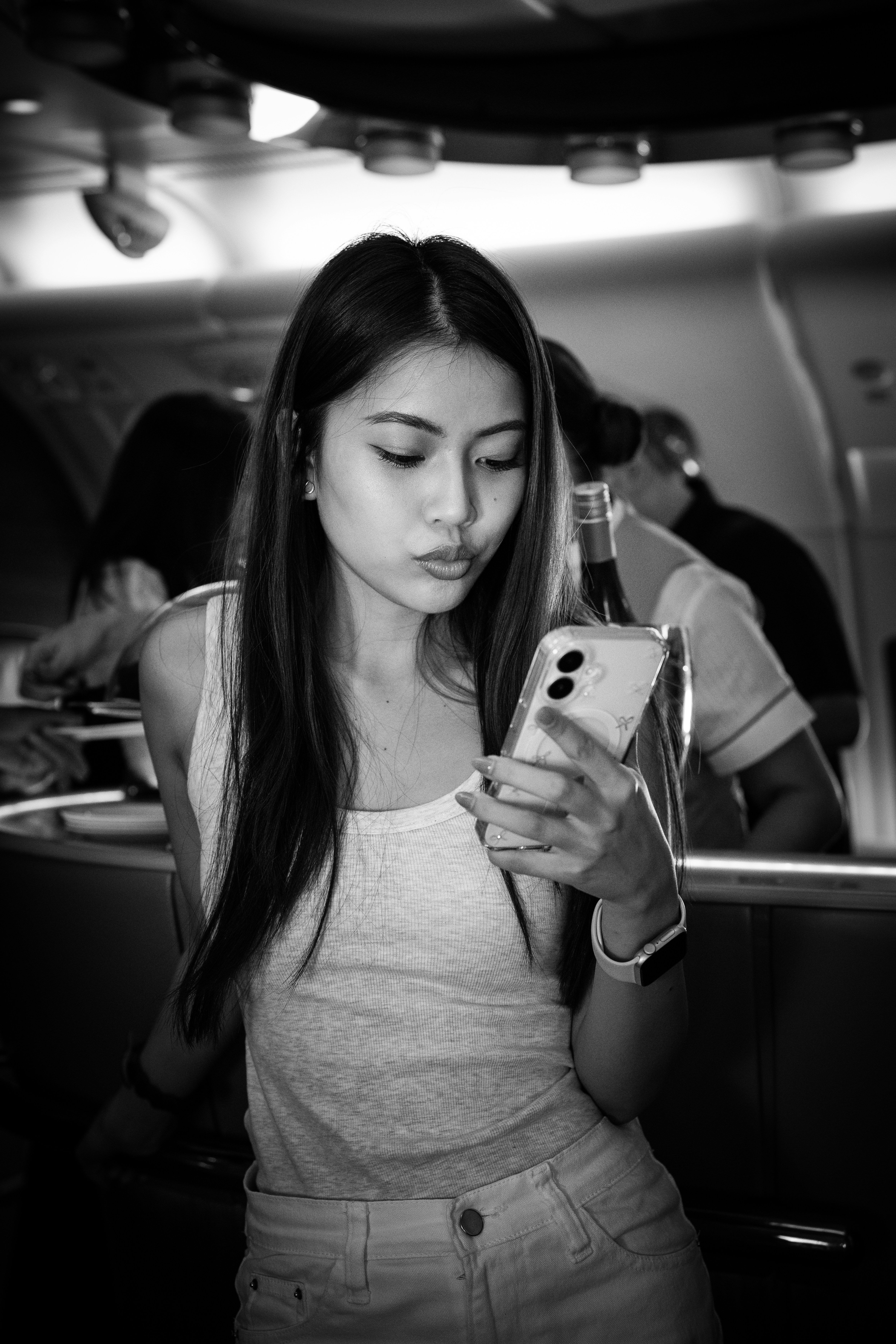 Woman on a plane looking at her phone.