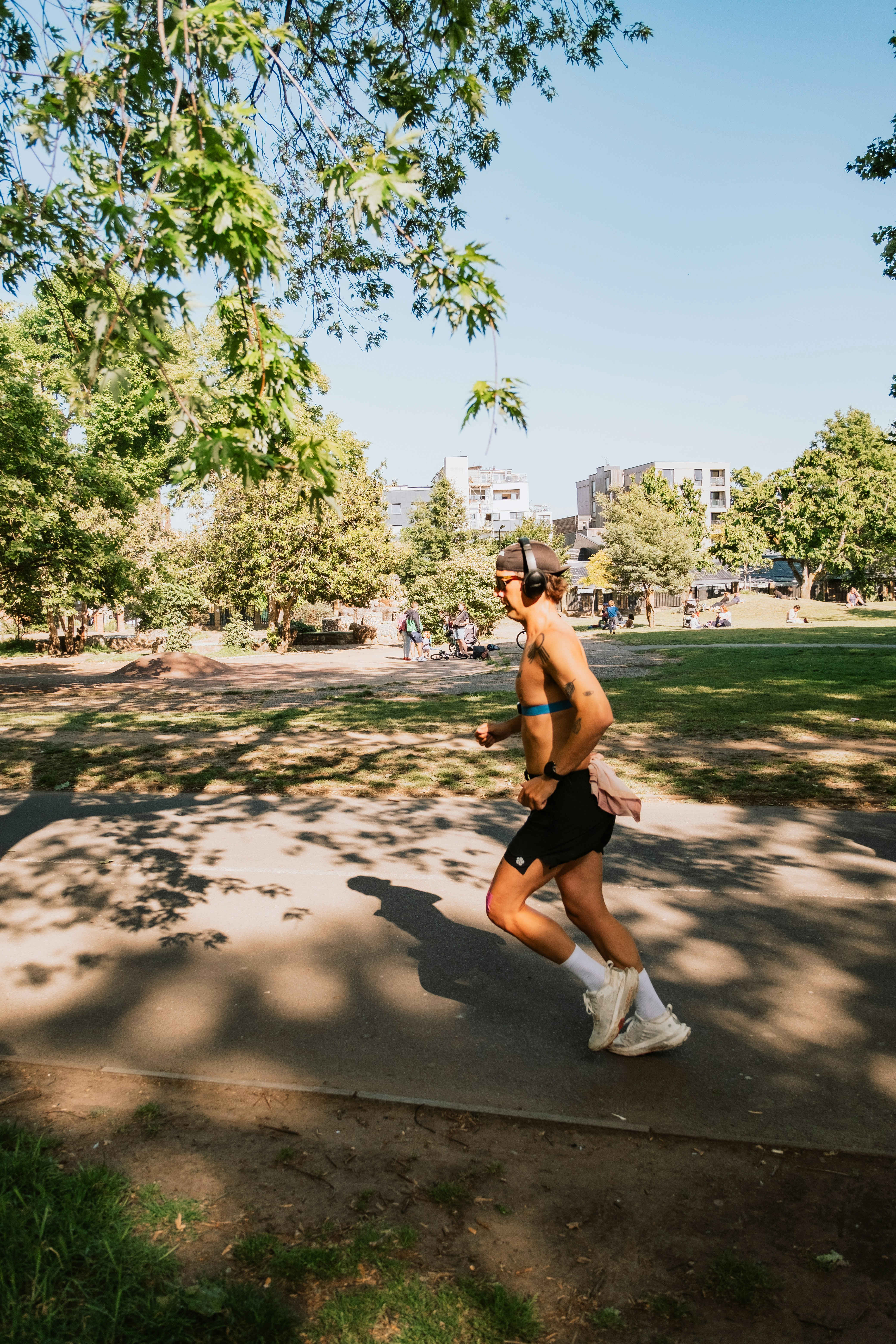 A man runs through a park on a sunny day.