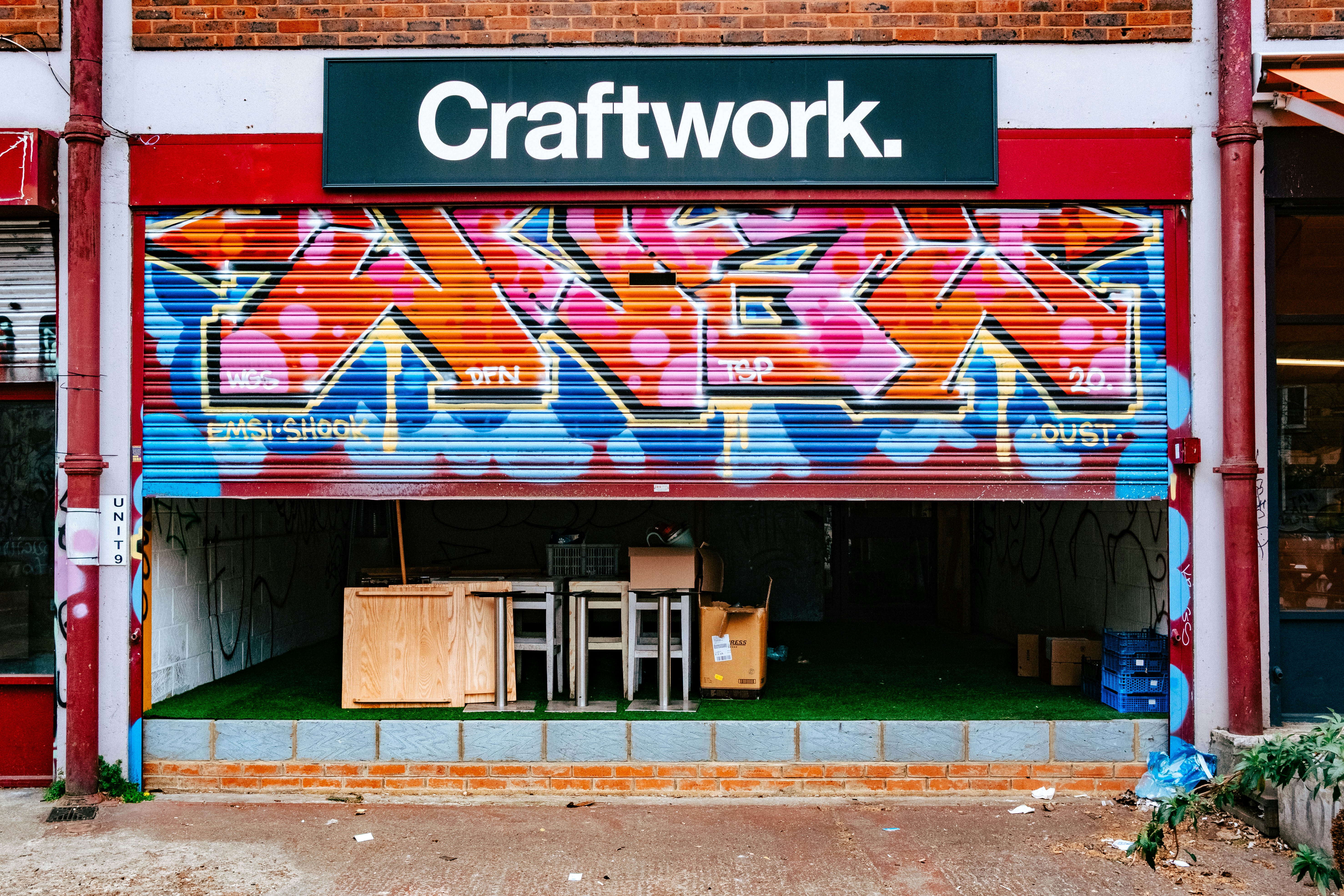 A storefront with a graffiti-covered security shutter.