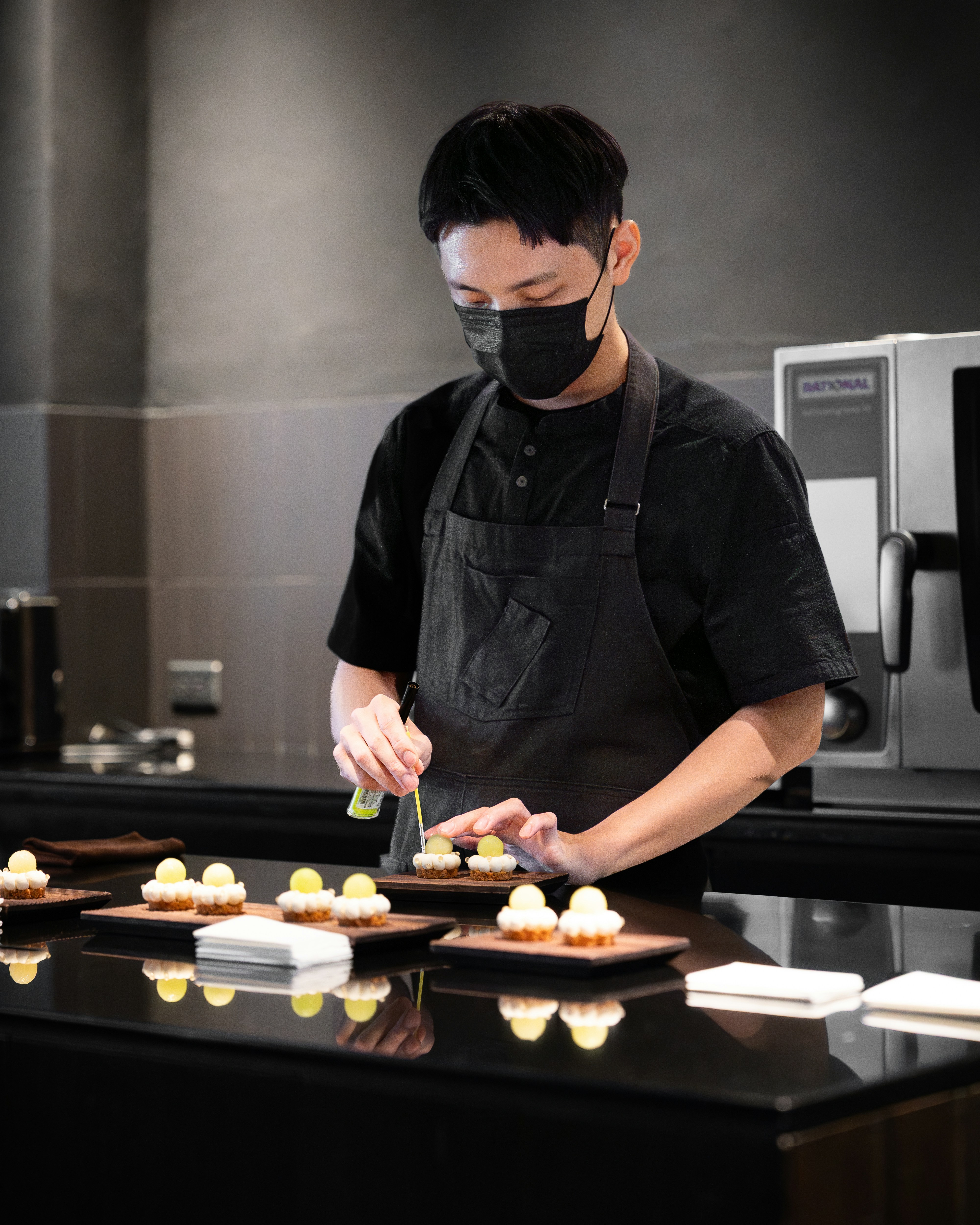 A chef is preparing a small dish.
