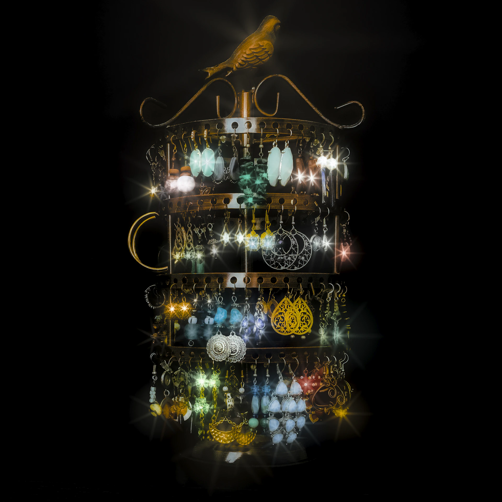 Earring display with illuminated earrings and bird.