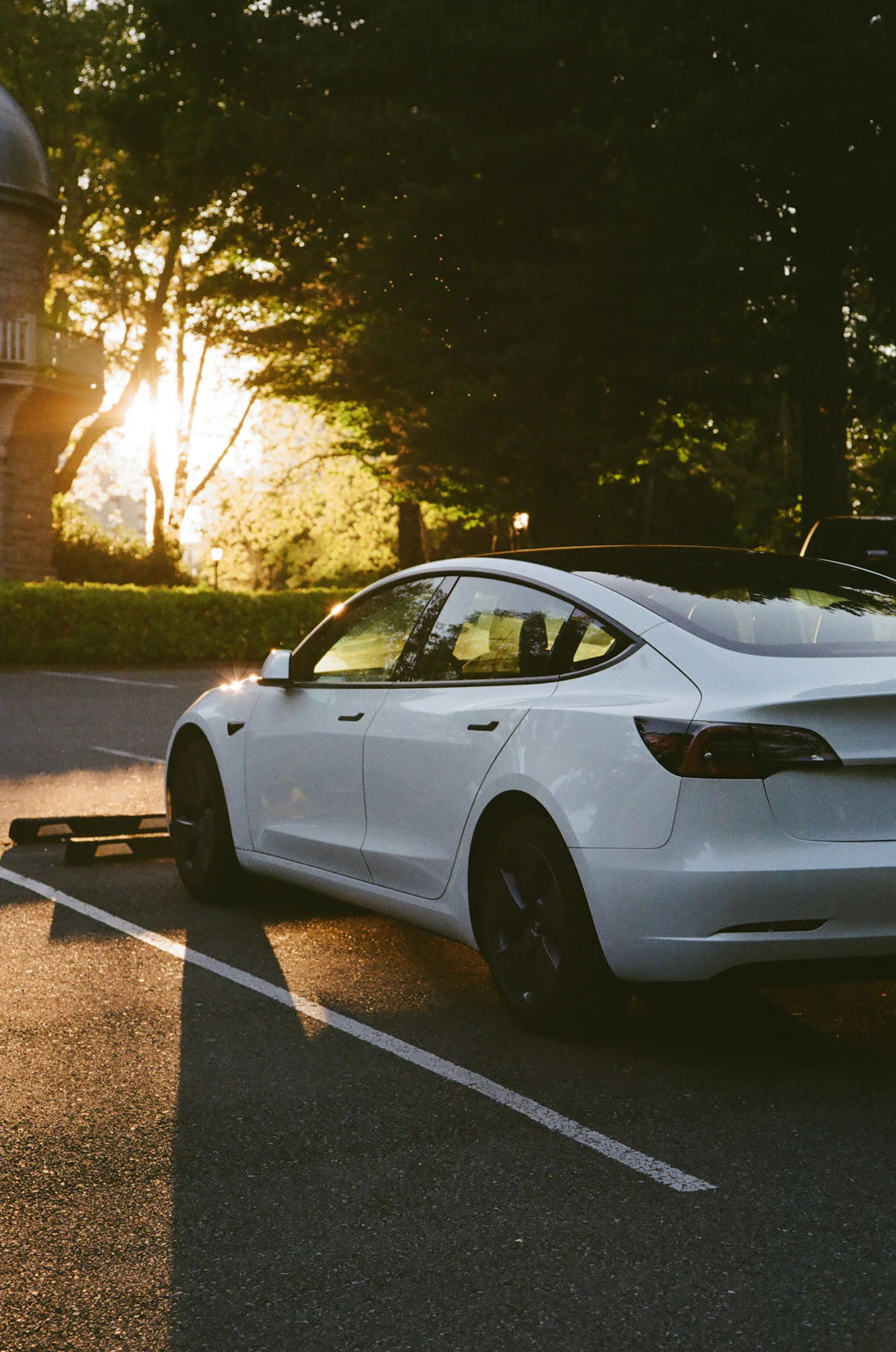 White Tesla Model 3 sedan parked in sunlight showing sleek exterior