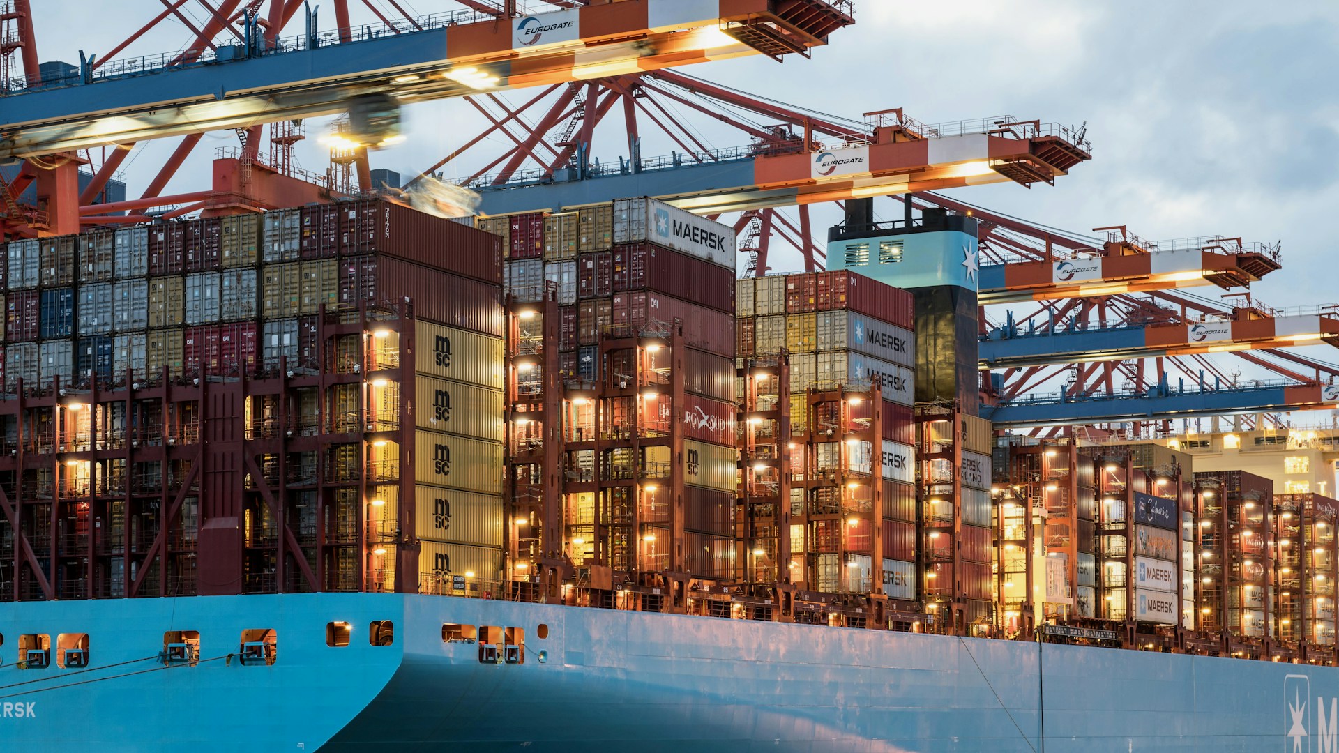 Shipping containers are being loaded on a vessel.