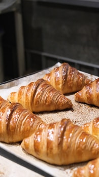 Freshly baked croissants on a baking sheet.