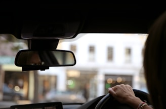 Driving view inside a car with a street in the background.