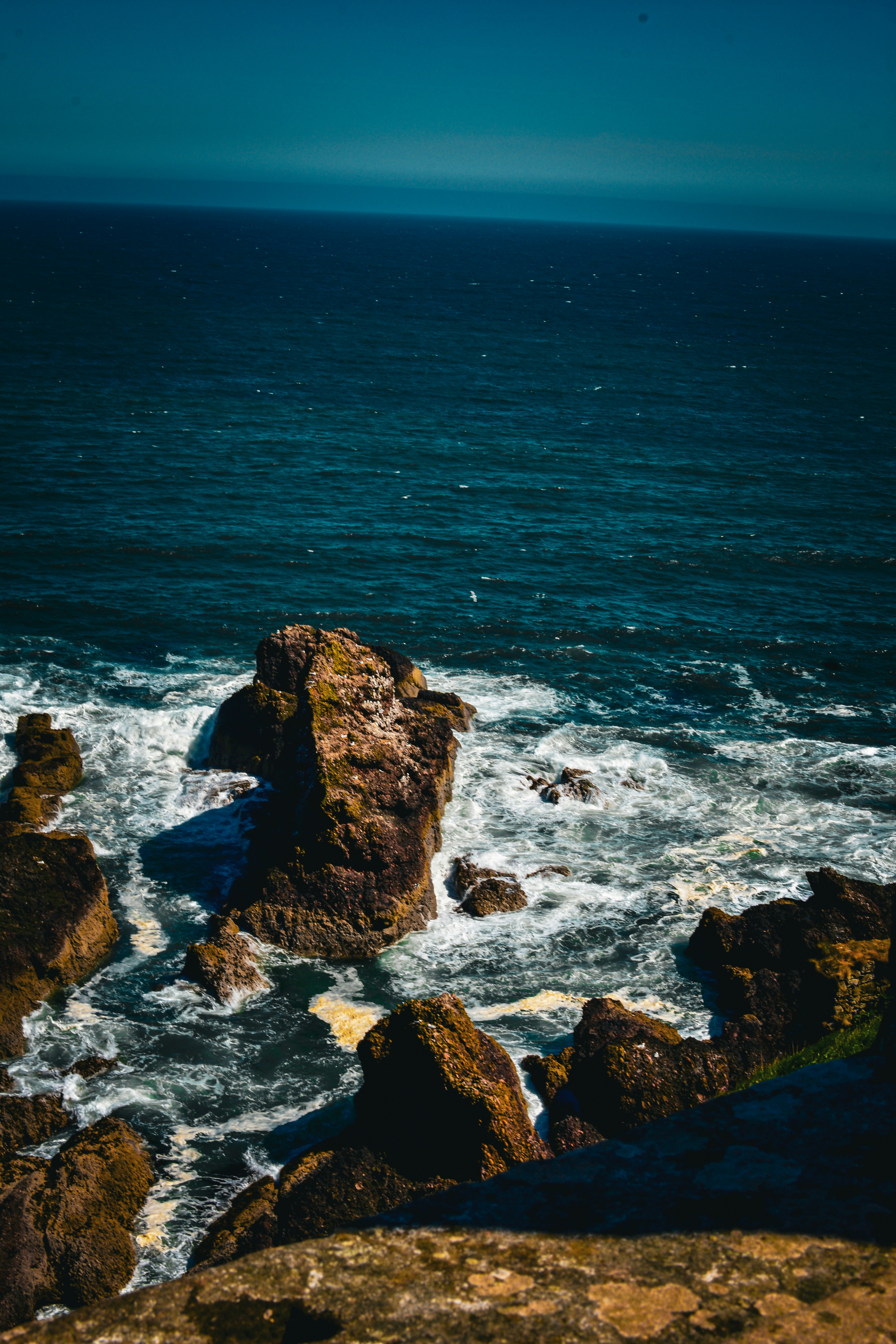 Ocean waves crash against rocky cliffs.