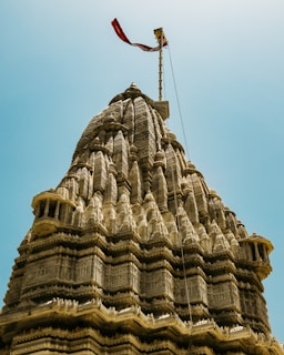 An ornate temple spire against a blue sky.