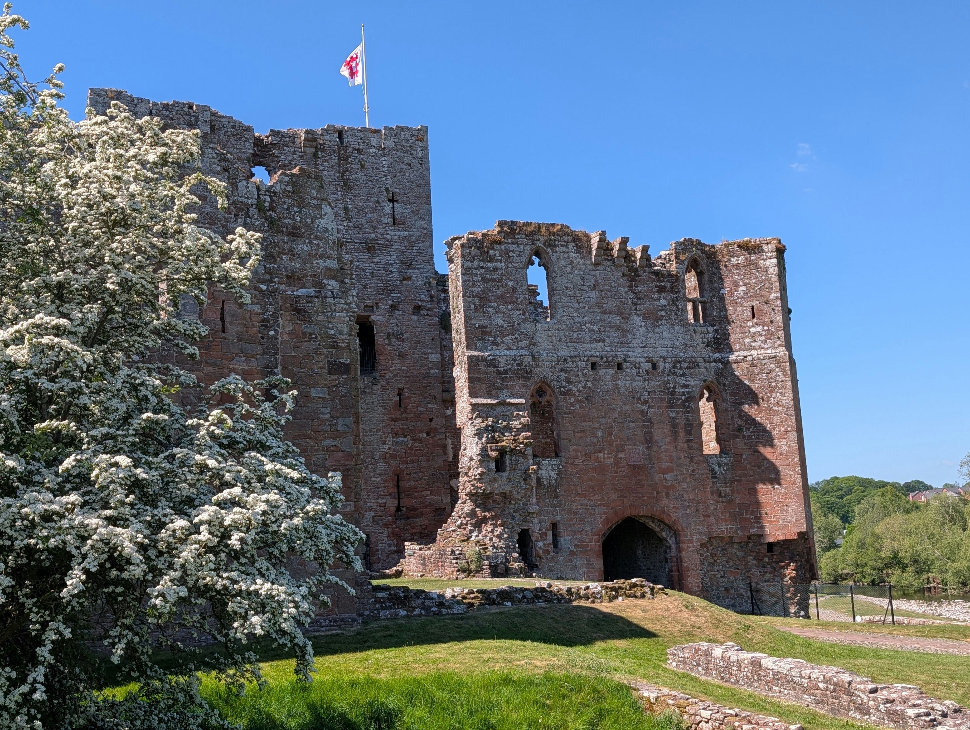 Die Ruinen einer alten Burg heben sich vor einem strahlenden Himmel ab.