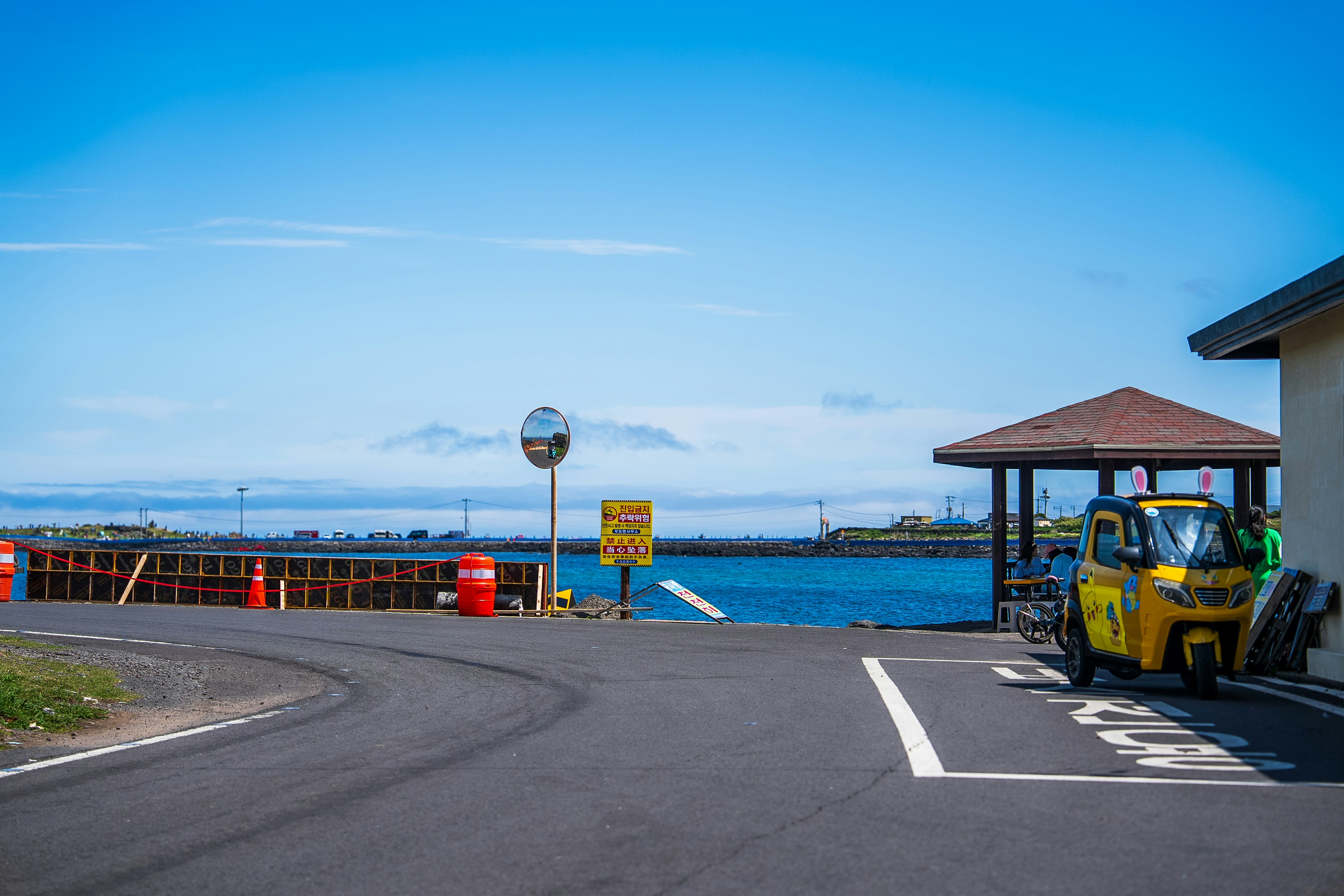 A yellow tuk-tuk sits at the harbor