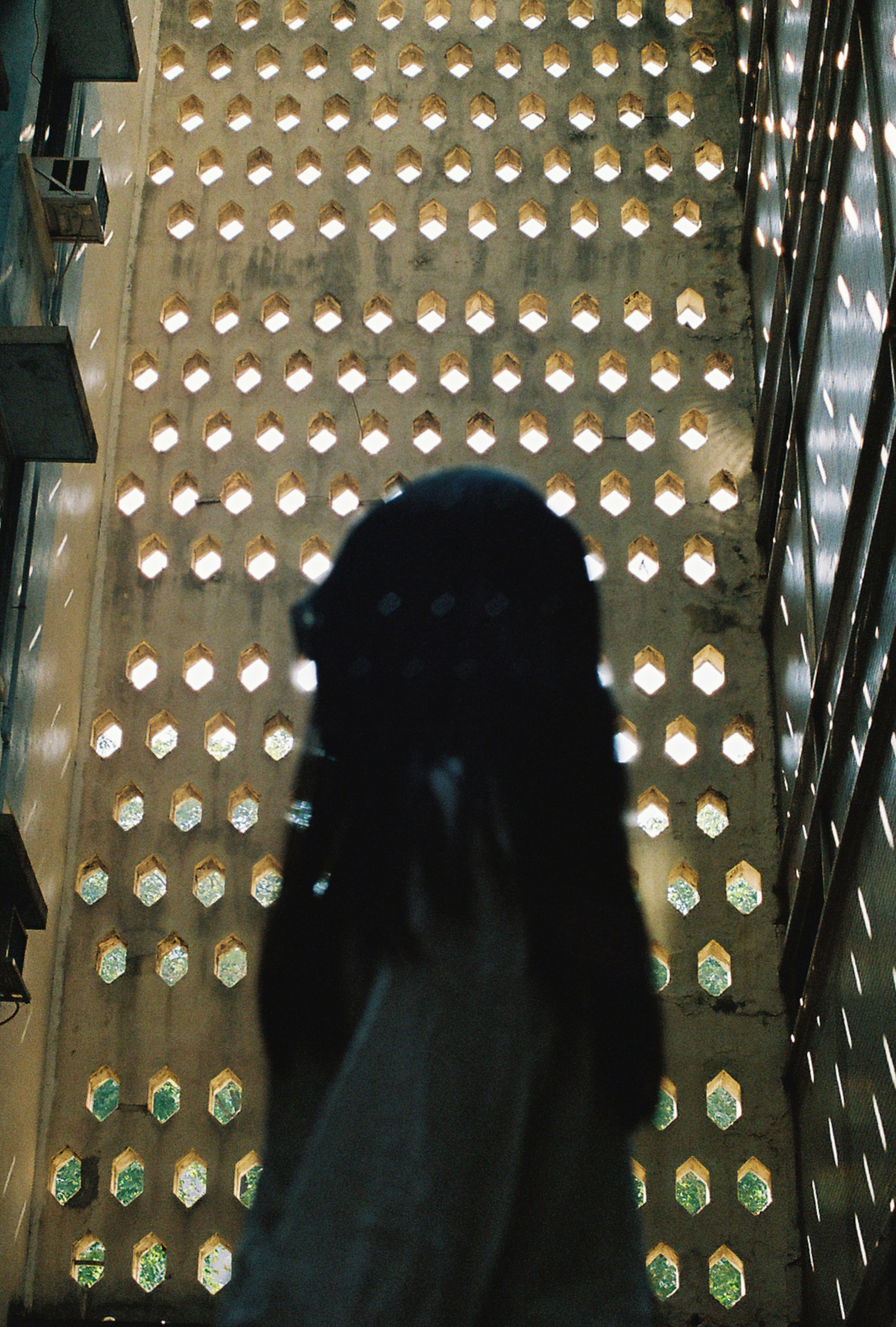 A silhouette stands in front of a wall.