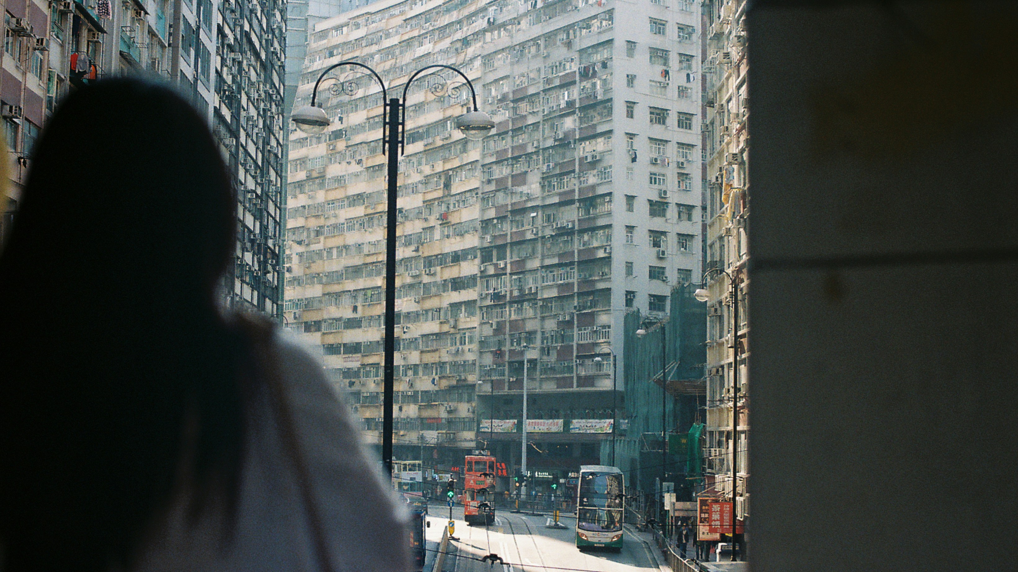 Woman views tall buildings in a bustling city.