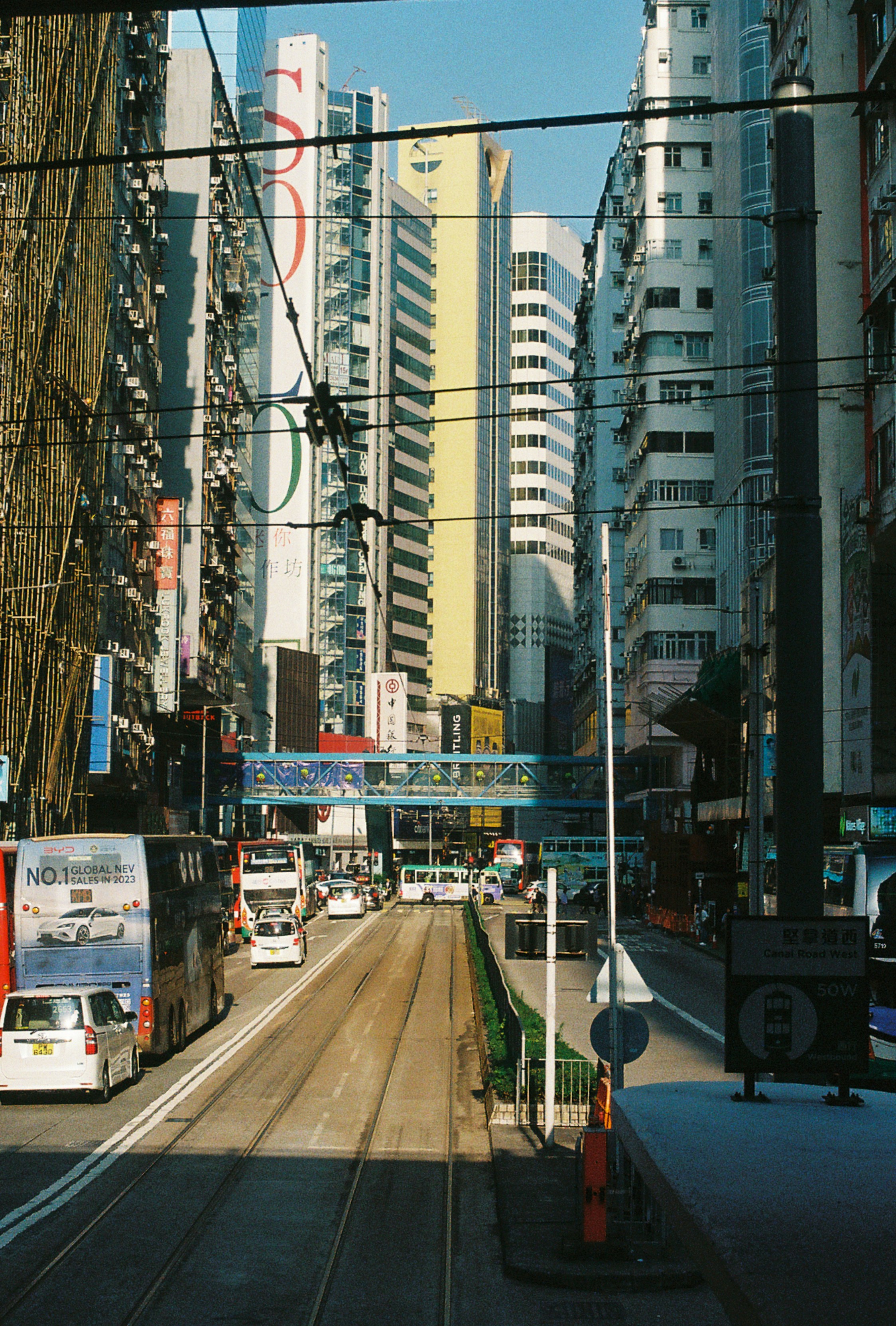 City street with tall buildings and public transportation.