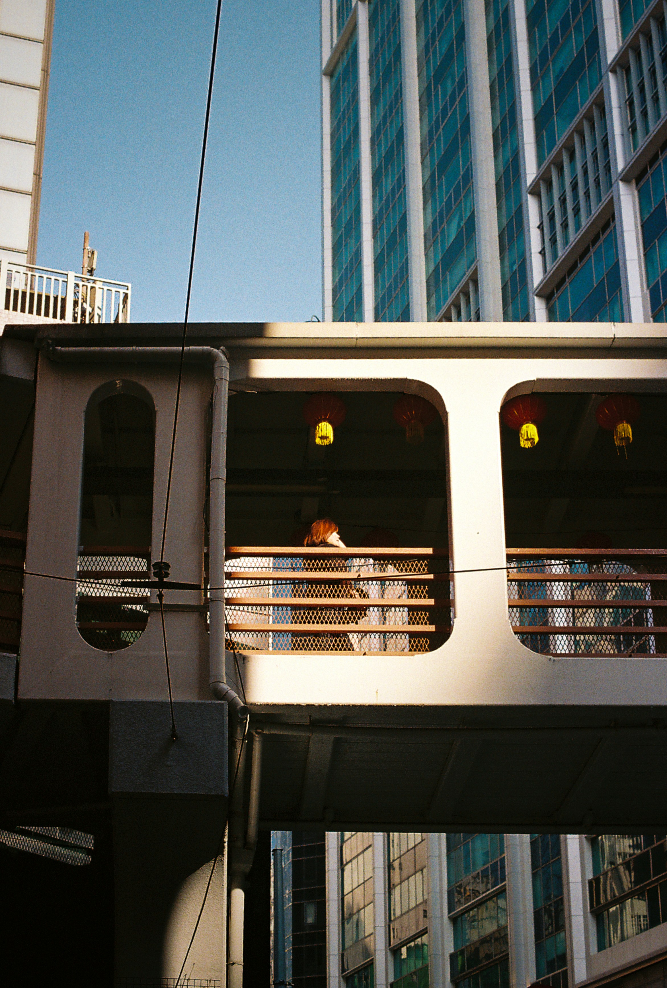 A person stands on a pedestrian bridge.