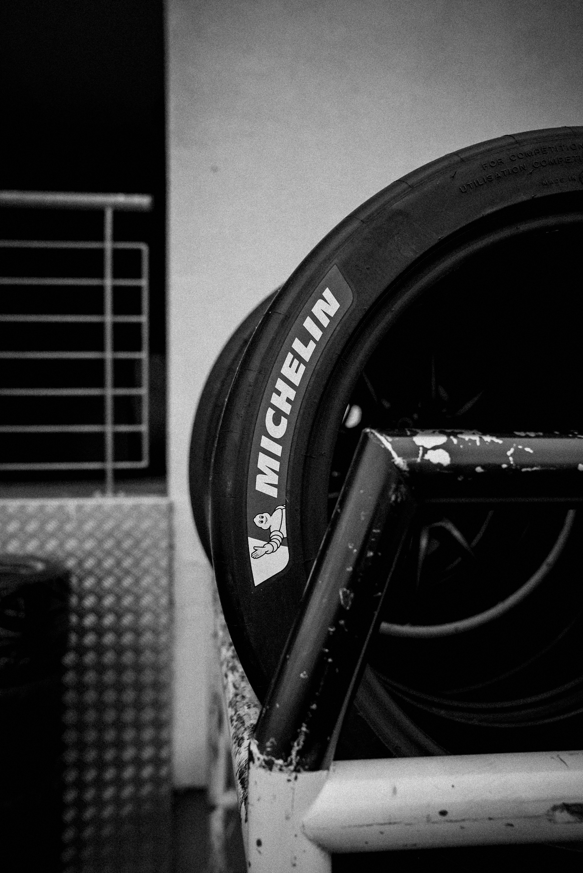 Michelin tires are stacked on a metal rack.