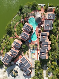 Resort with solar panels and a pool by the water.